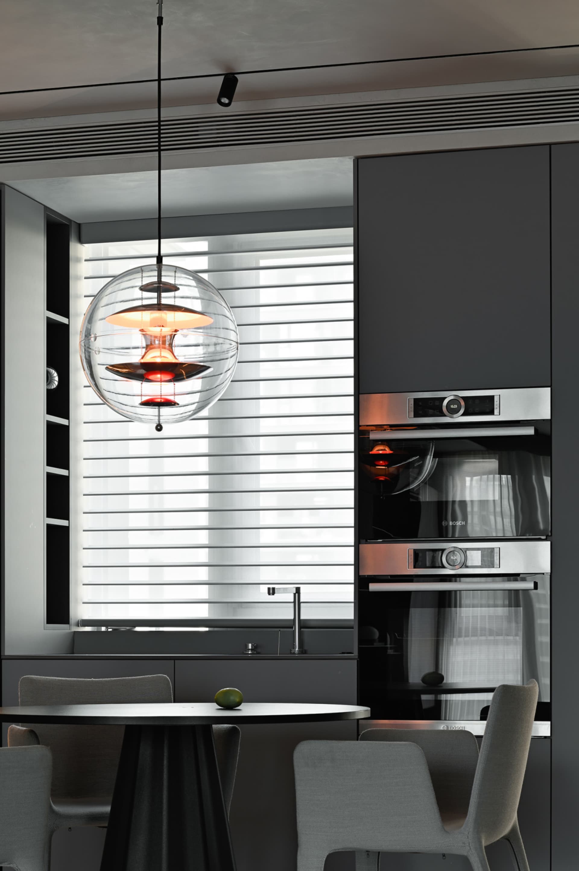 A minimalist kitchen featuring modern metal and glass elements.