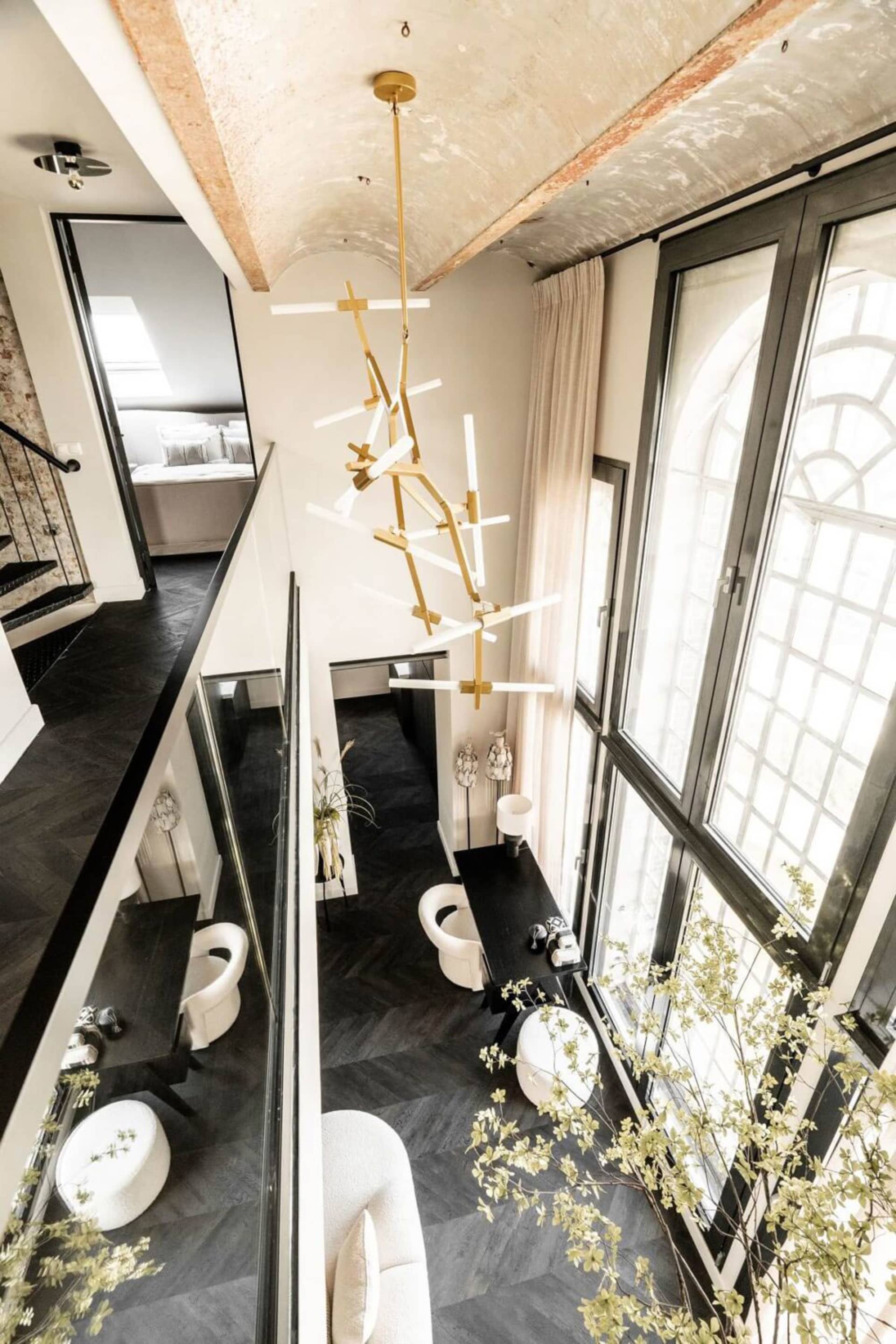 Modern interior space featuring black and white lighting fixtures, large windows, and white curtains.