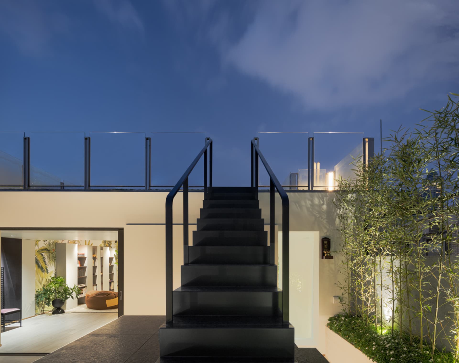 Modern black staircase with metal railings and glass walls, featuring a clean, minimalist design.