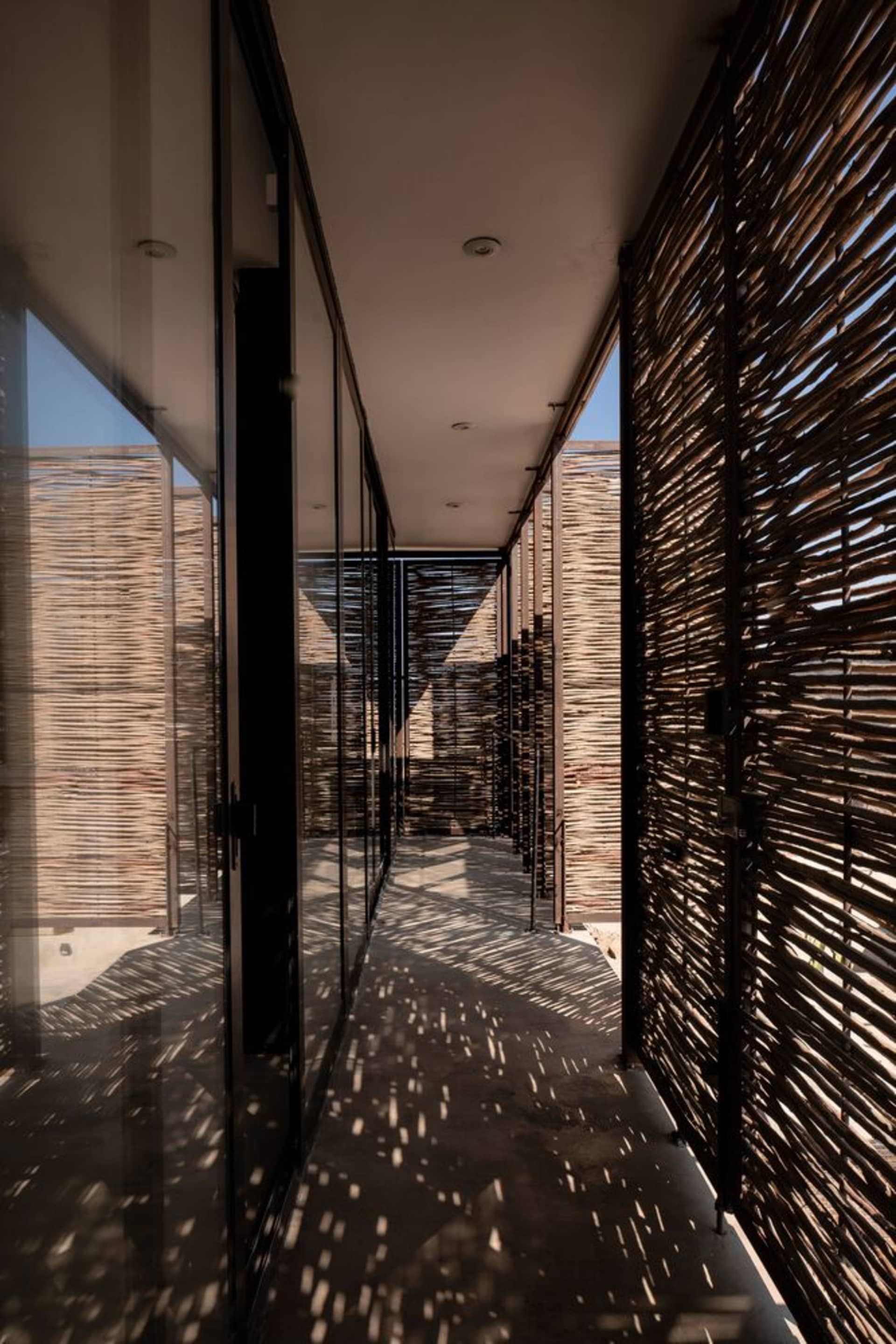 Industrial-style interior with bamboo walls and floors, featuring geometric patterns and geometric shapes created by shadows