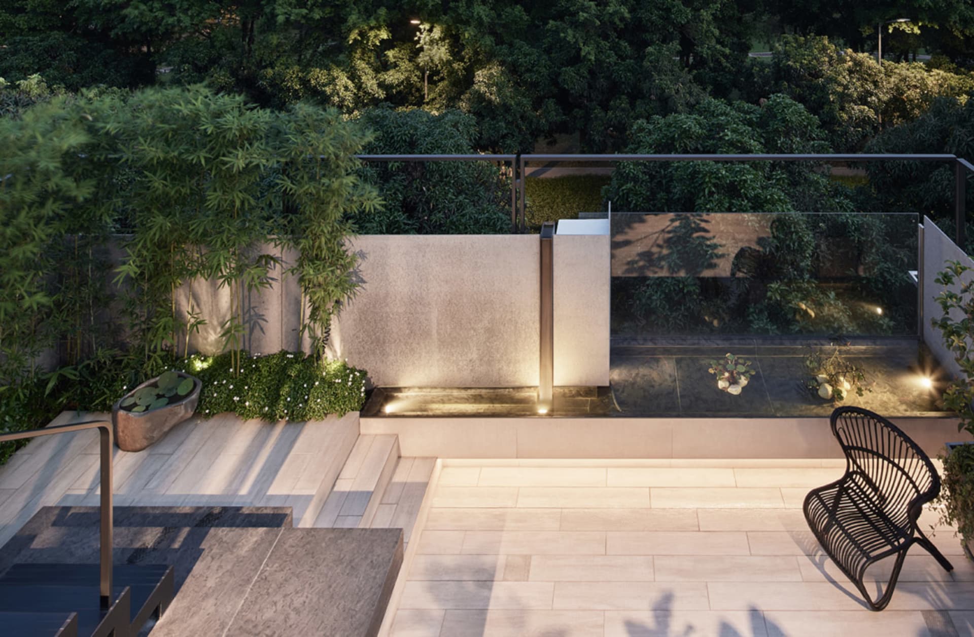 A modern rooftop garden with natural stone furniture, surrounded by lush greenery and illuminated by warm lights.