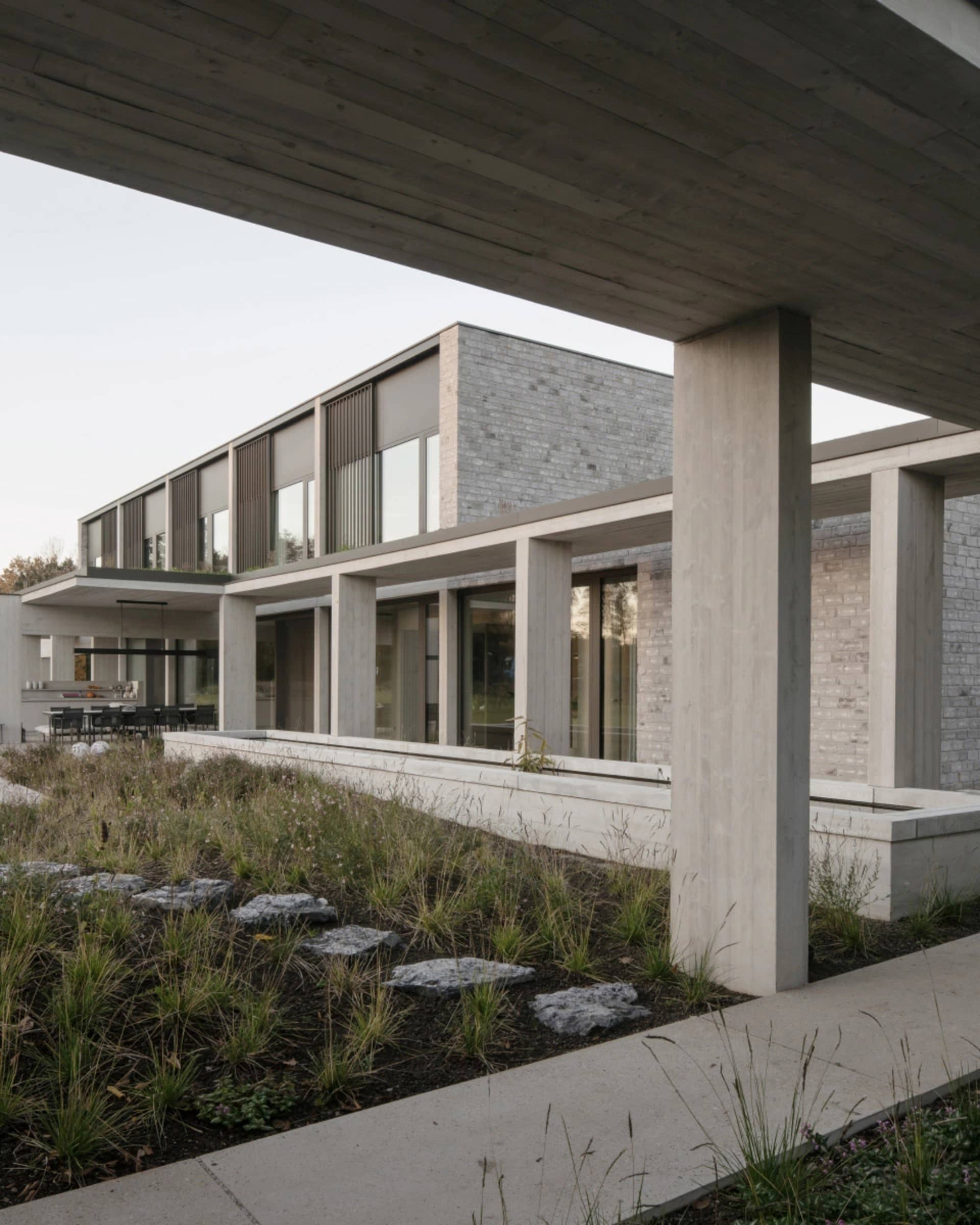 Modern residential house with concrete exterior and large windows.