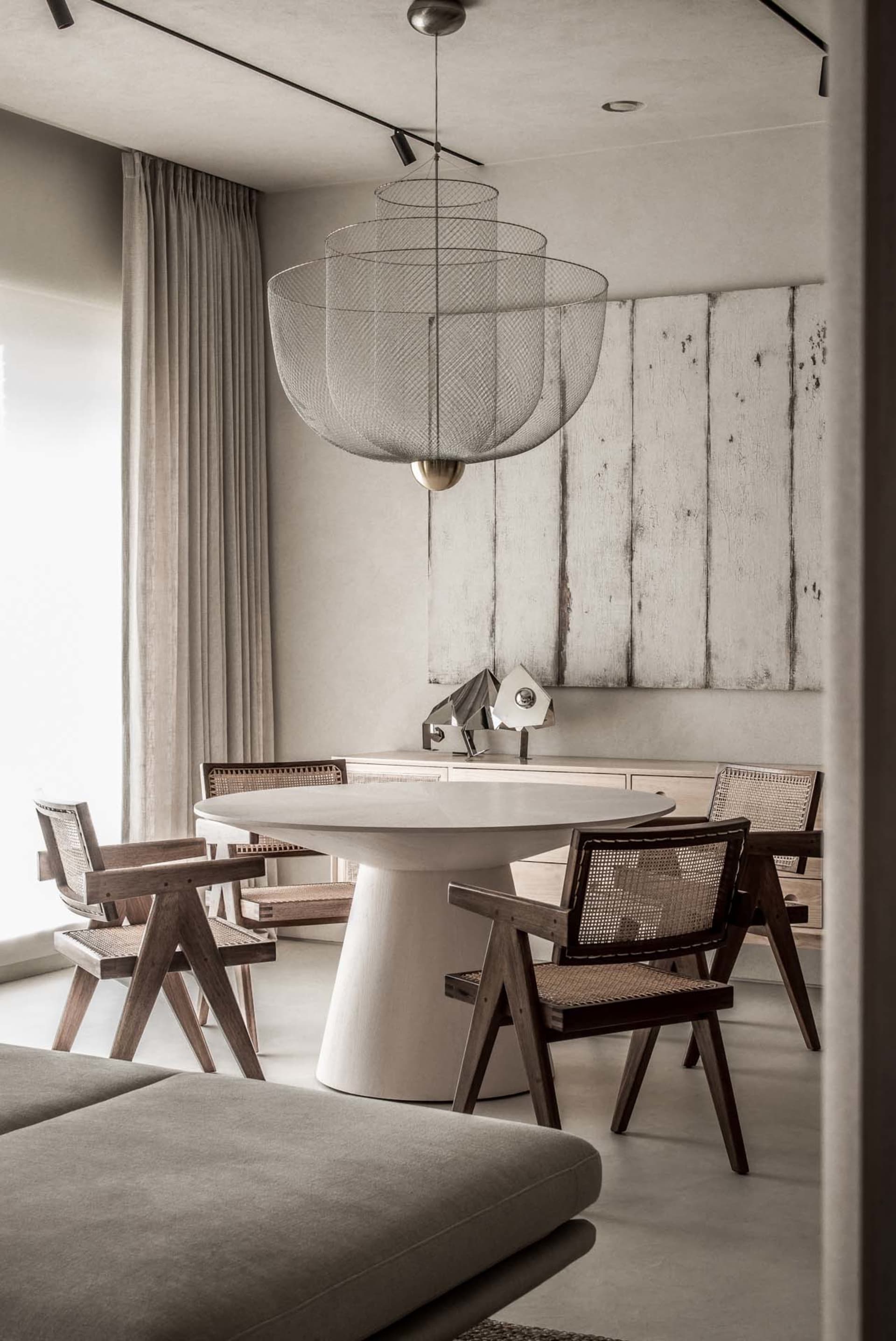 Modern minimalist dining room featuring a metal mesh pendant light fixture.