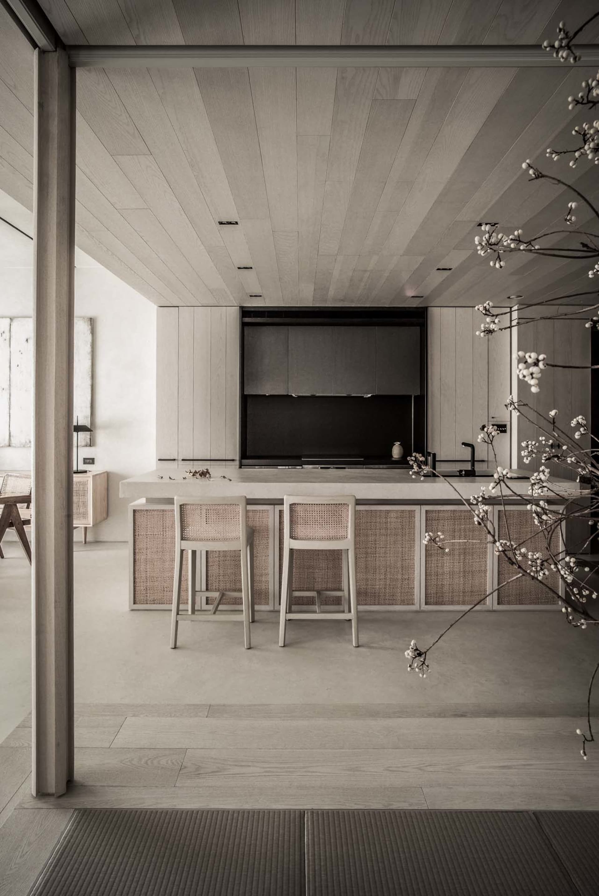 Modern minimalist residential kitchen featuring light-colored wooden cabinets and flooring.