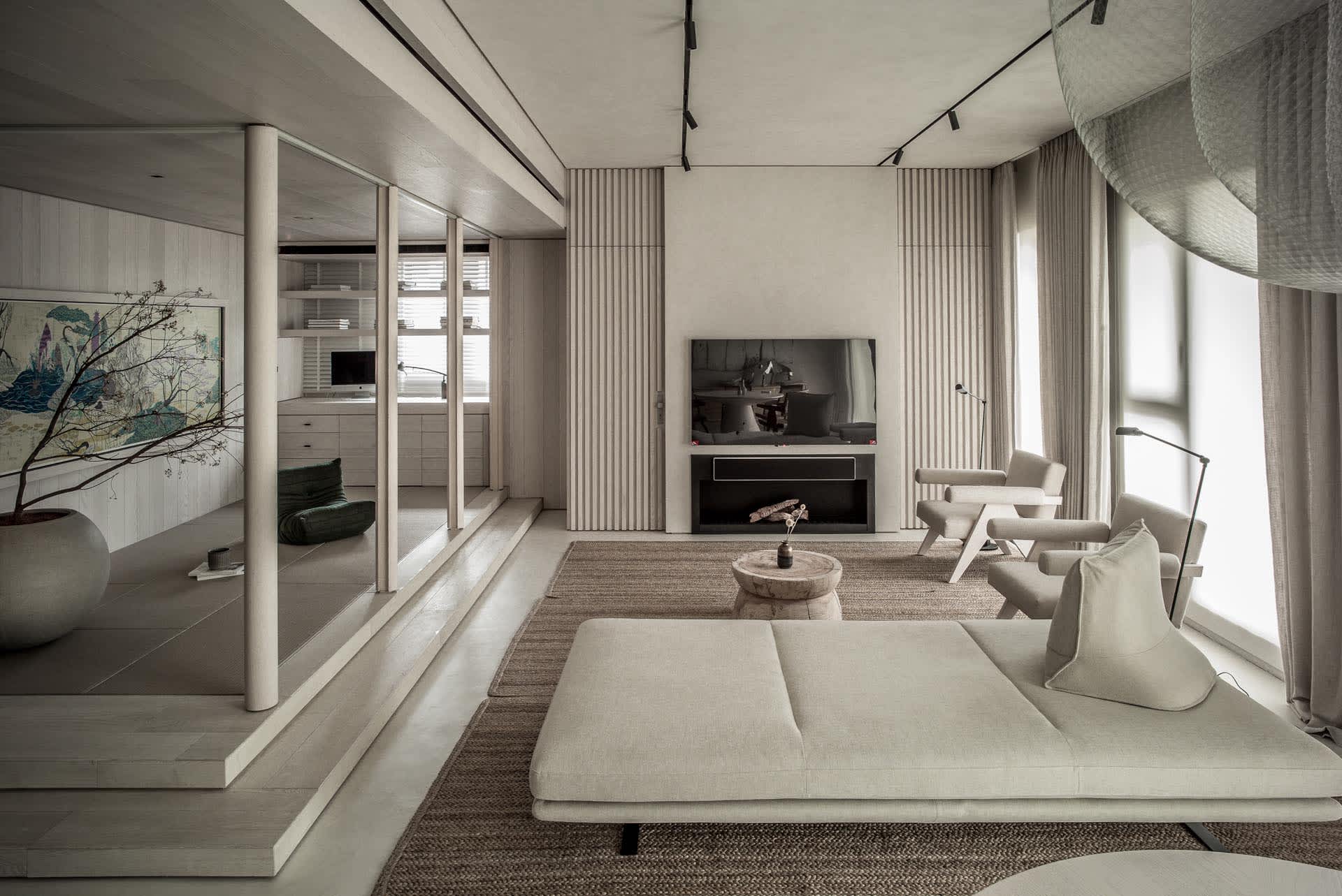 A modern minimalist living room with wood, concrete, and fabric materials and a low, comfortable sofa with a round wooden sid