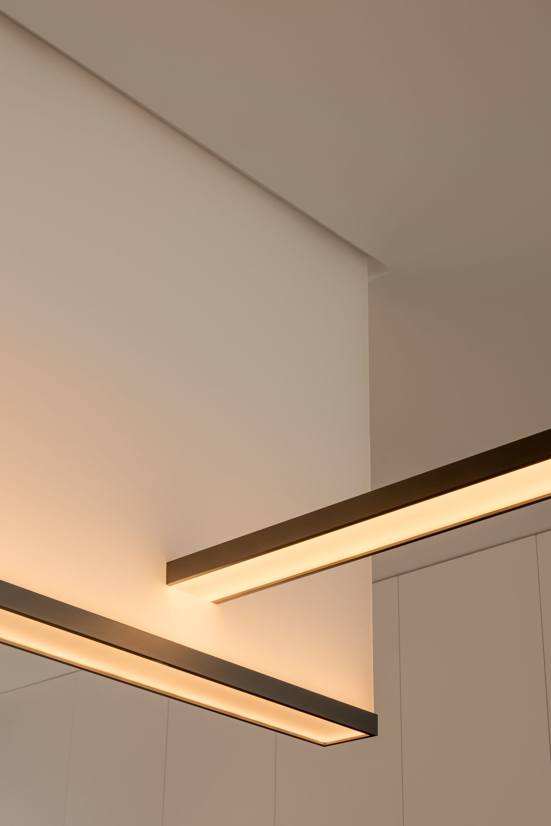 Modern, minimalist interior design featuring sleek, metallic lighting fixtures.