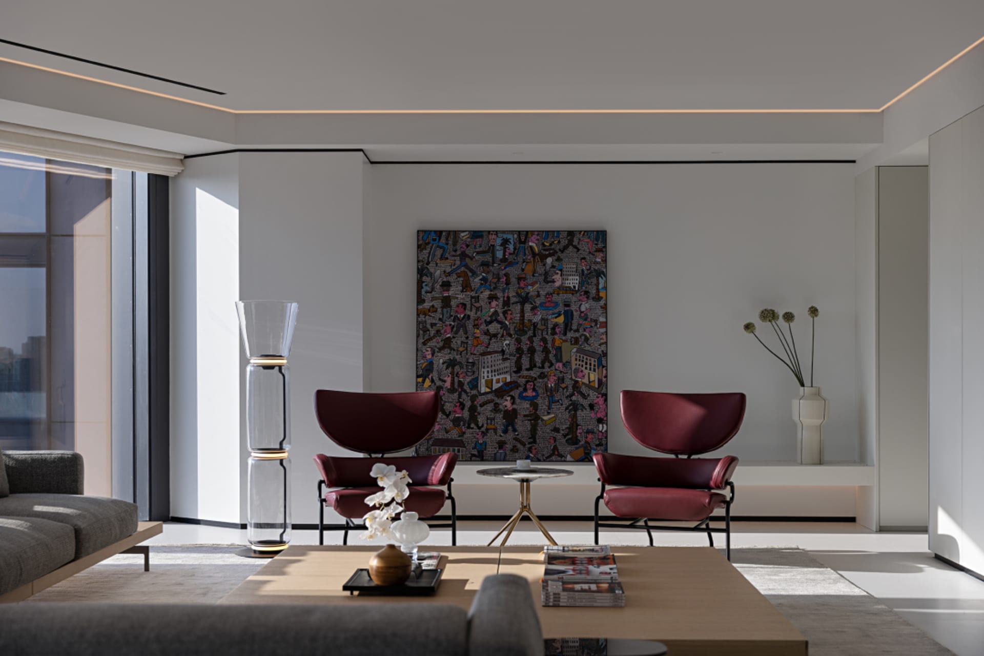 Contemporary living room featuring modern furniture with marble, glass, and upholstered elements.