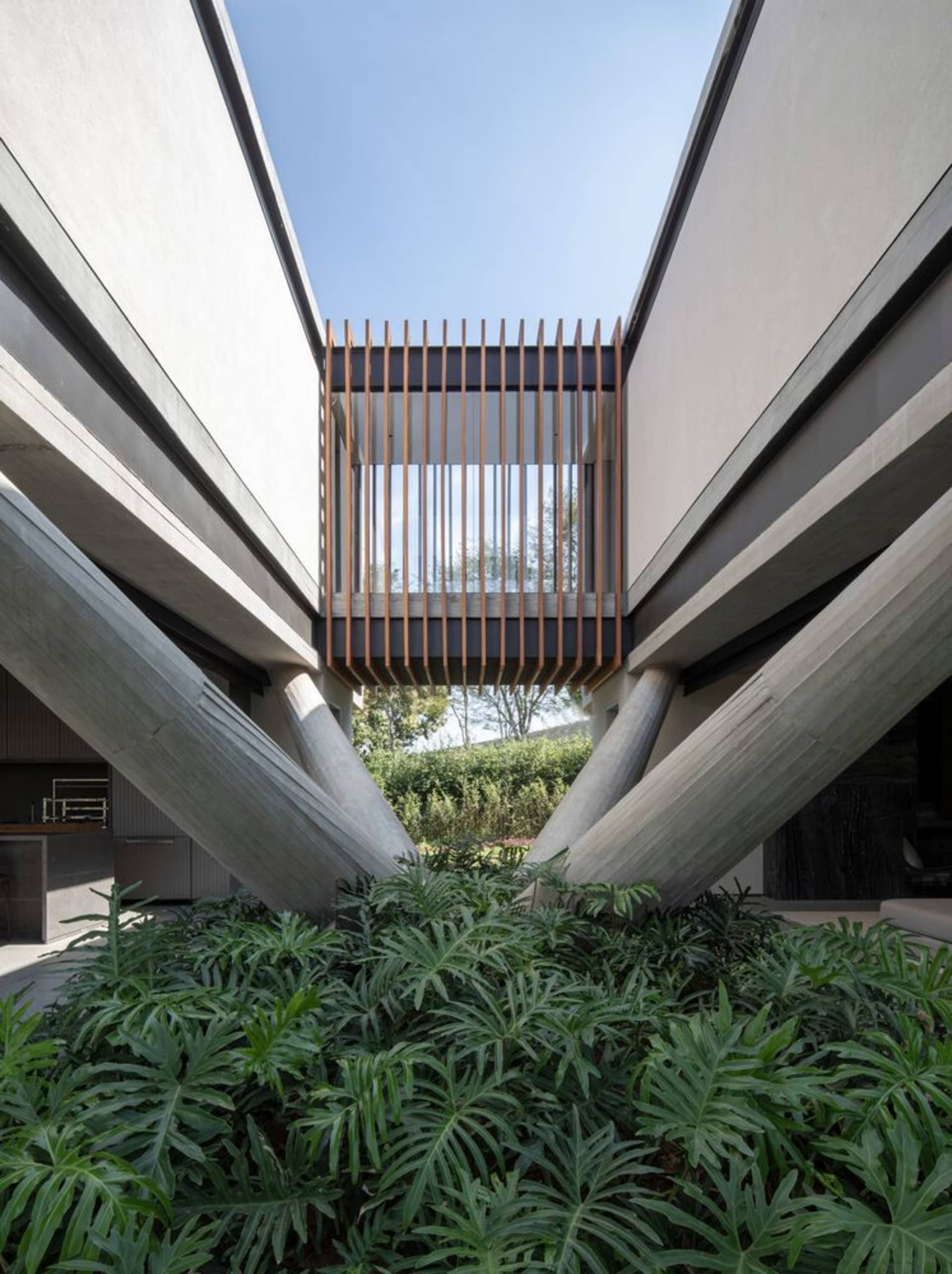 現代外觀建築設計，採用混凝土材質，背景為清澈藍天。