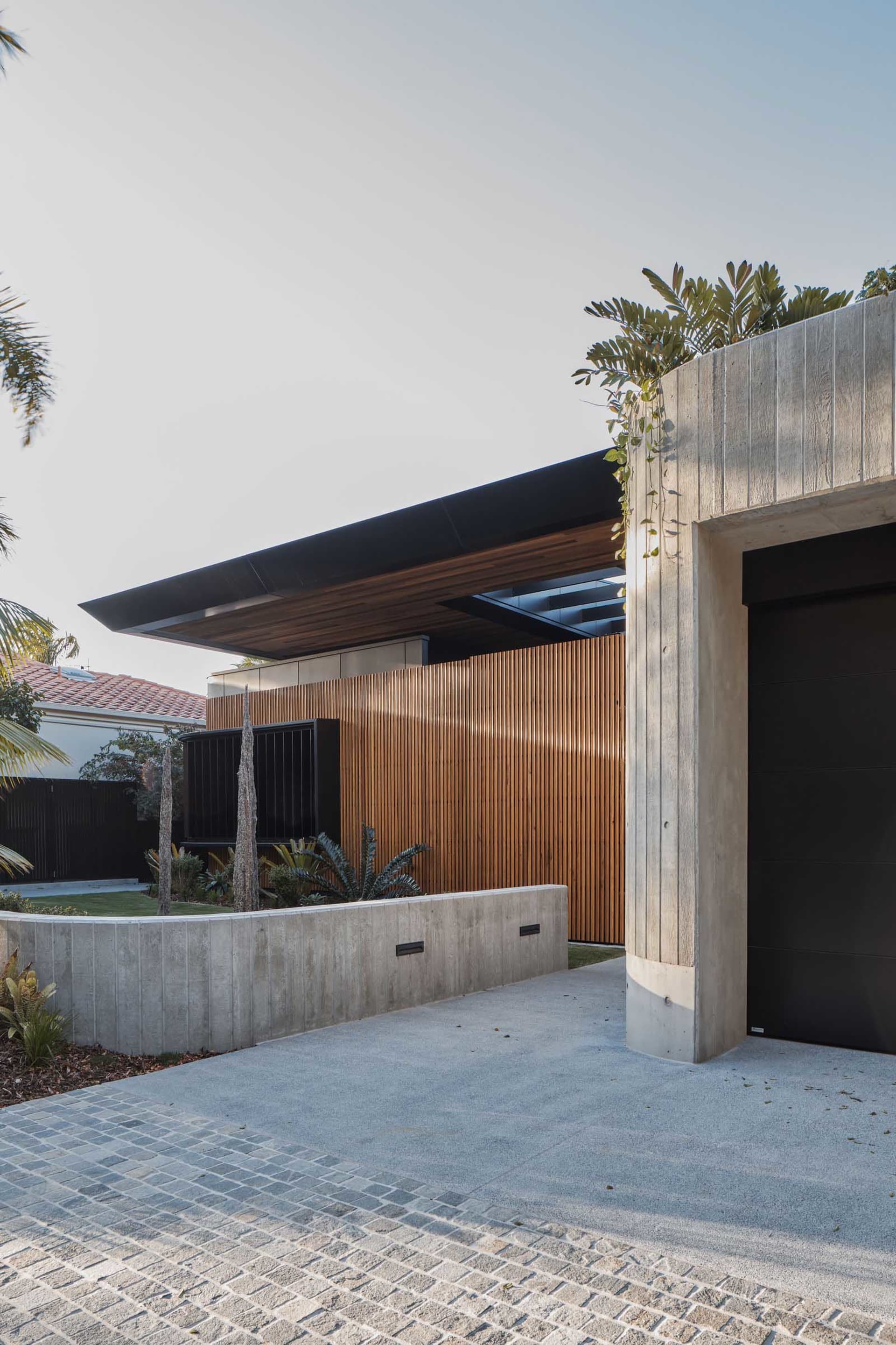 Modern house entrance featuring a contemporary design with concrete and wooden elements.