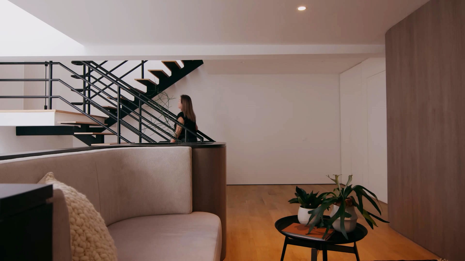 A modern residential living space featuring white concrete and steel materials, with a minimalist design aesthetic.