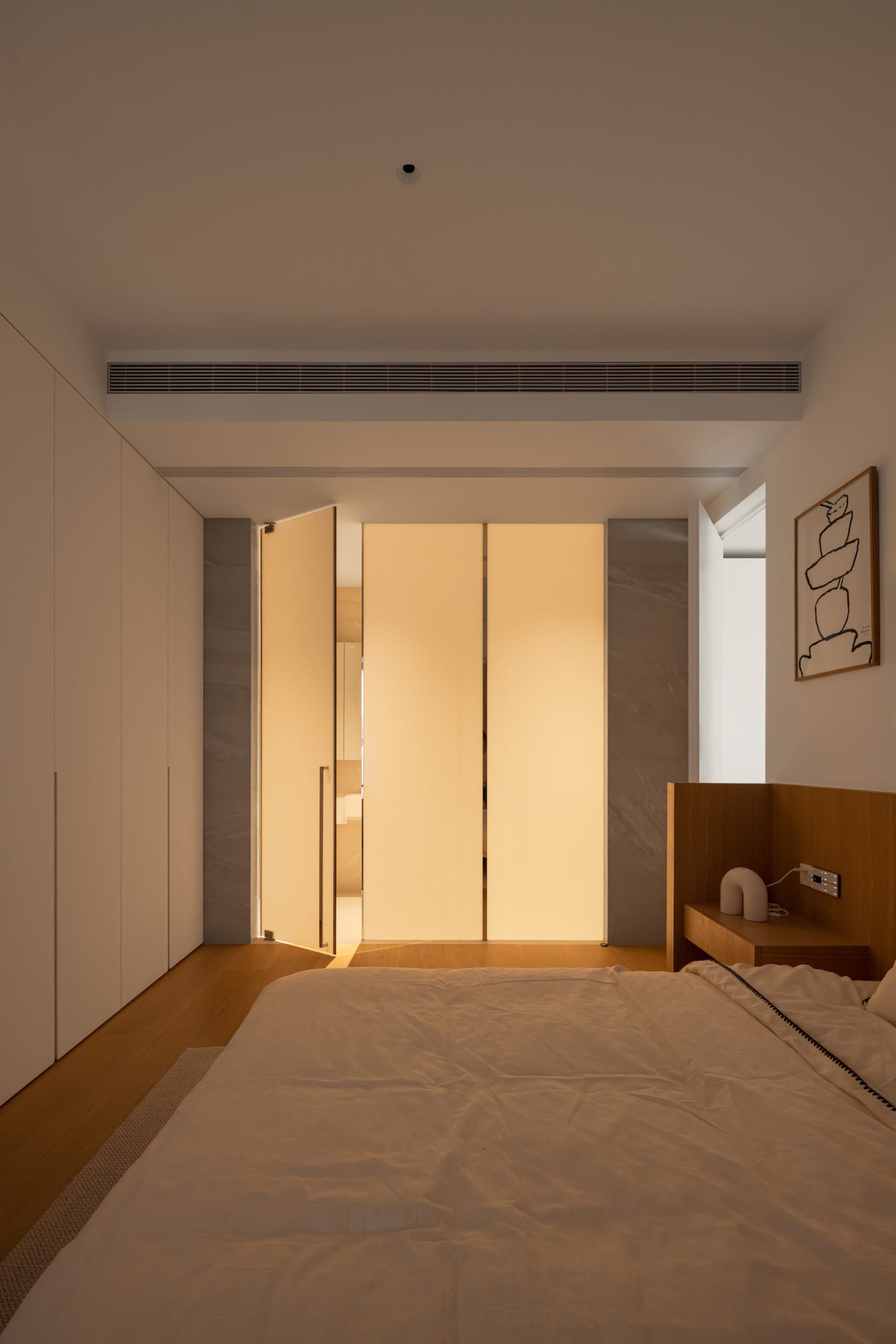 A modern minimalist bedroom with wooden flooring, marble accents, and a light-filled atmosphere.