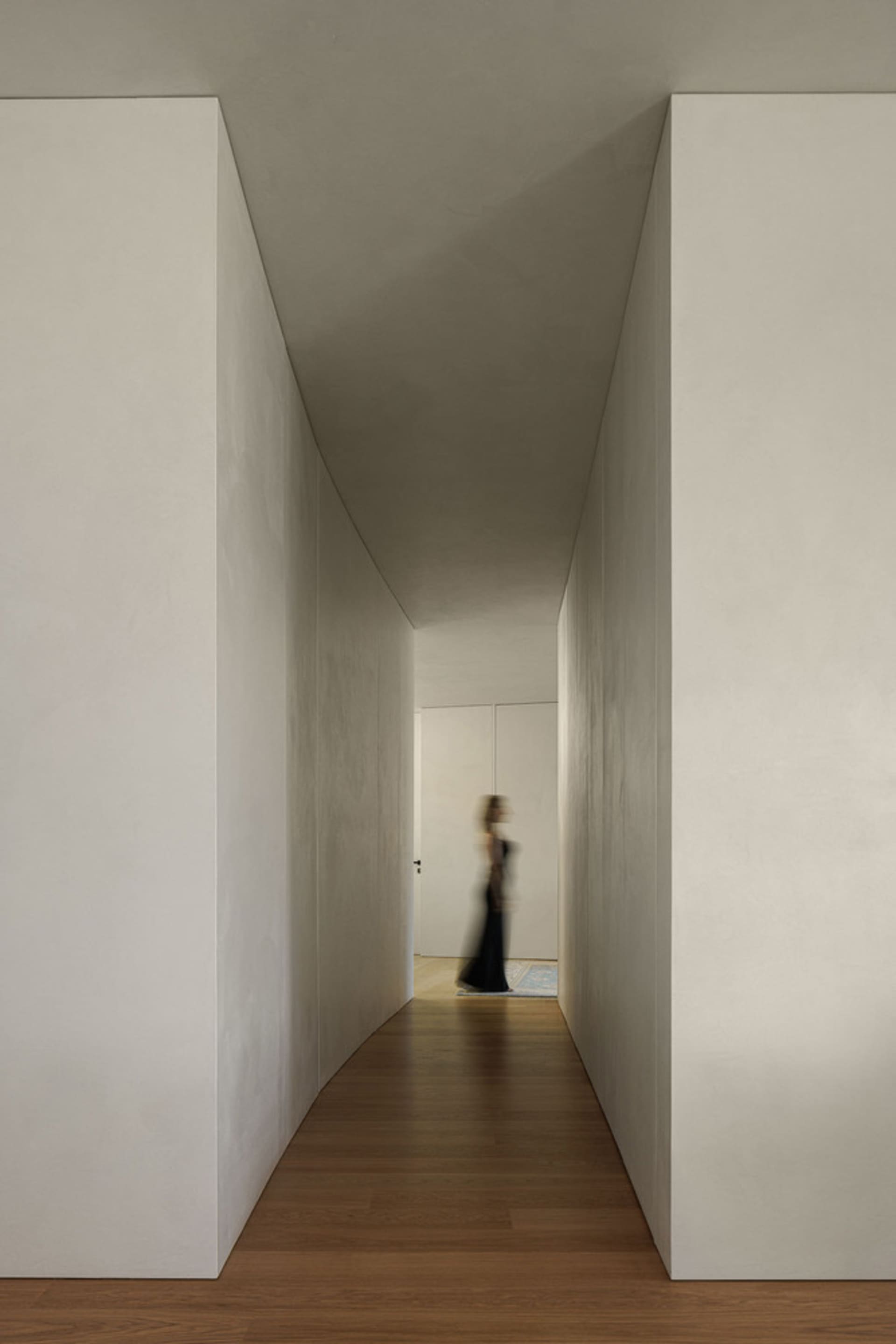 A minimalist hallway with concrete walls and wooden flooring