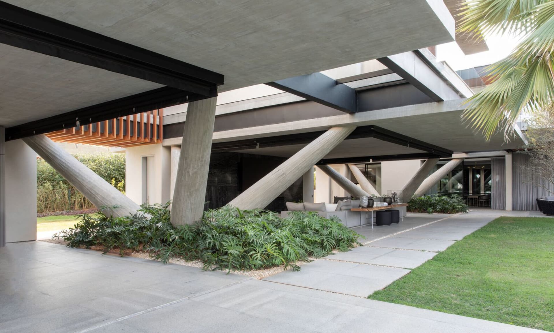 A modern residential exterior featuring concrete, glass, and metal elements.