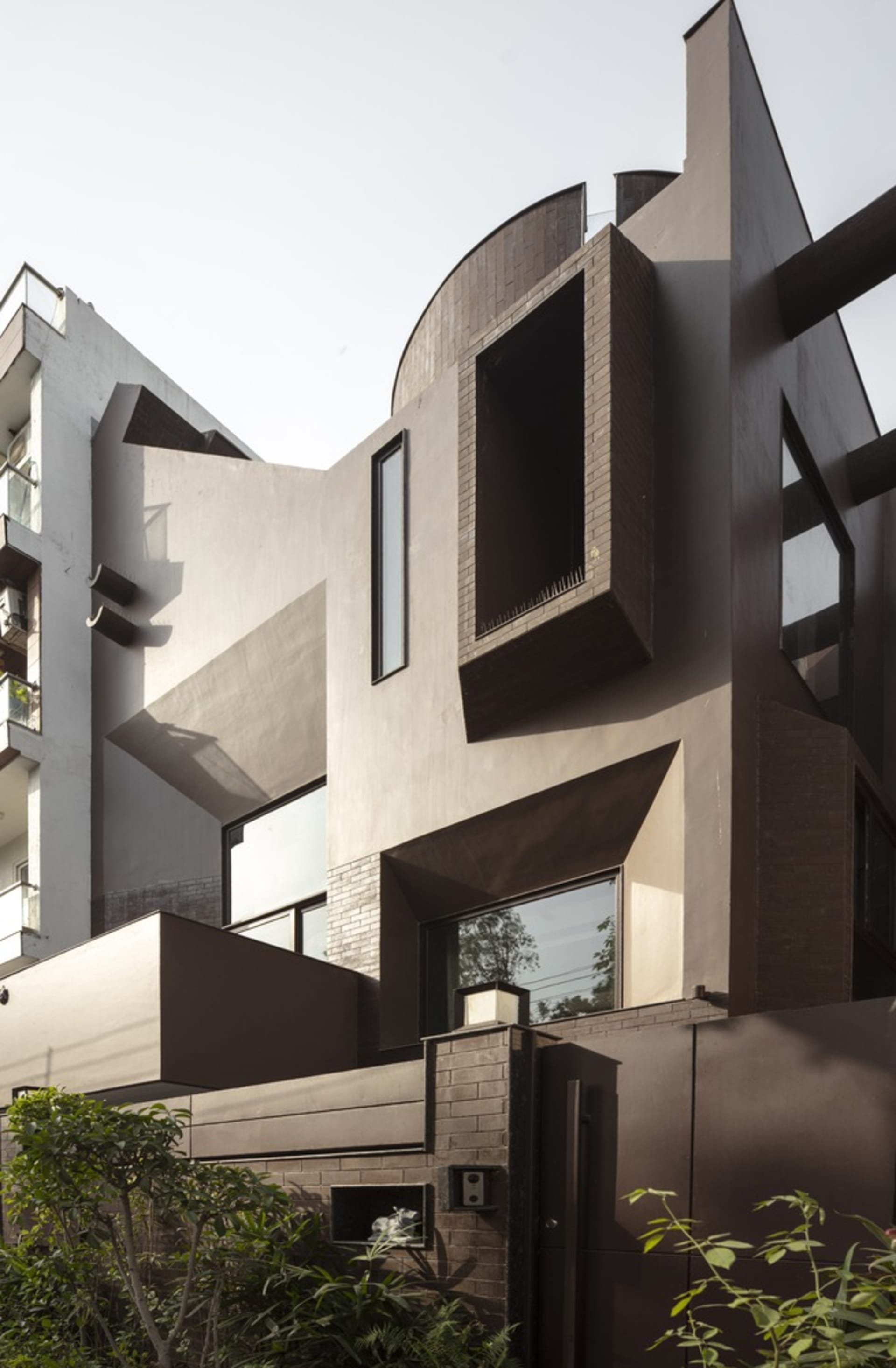 A modern building exterior constructed with concrete, featuring geometric shapes and large windows.