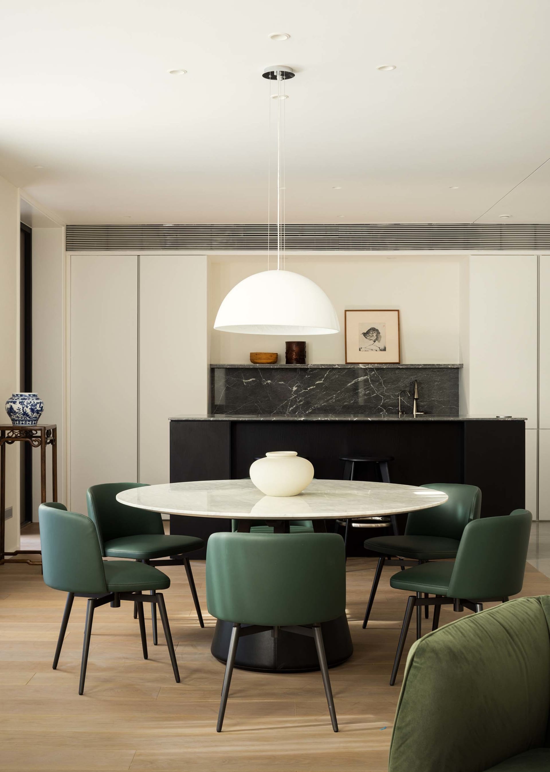 A modern living room with a wooden pendant light hanging from the ceiling.