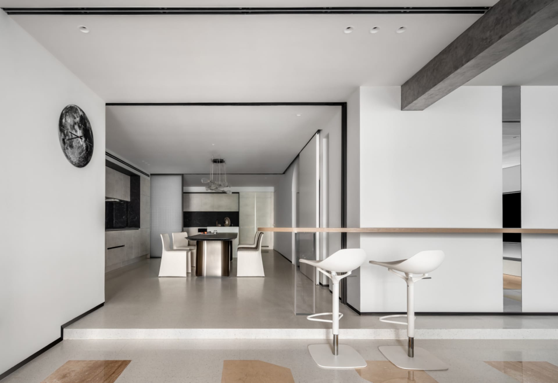 A modern minimalist kitchen with metal accents, glass elements, and concrete flooring.