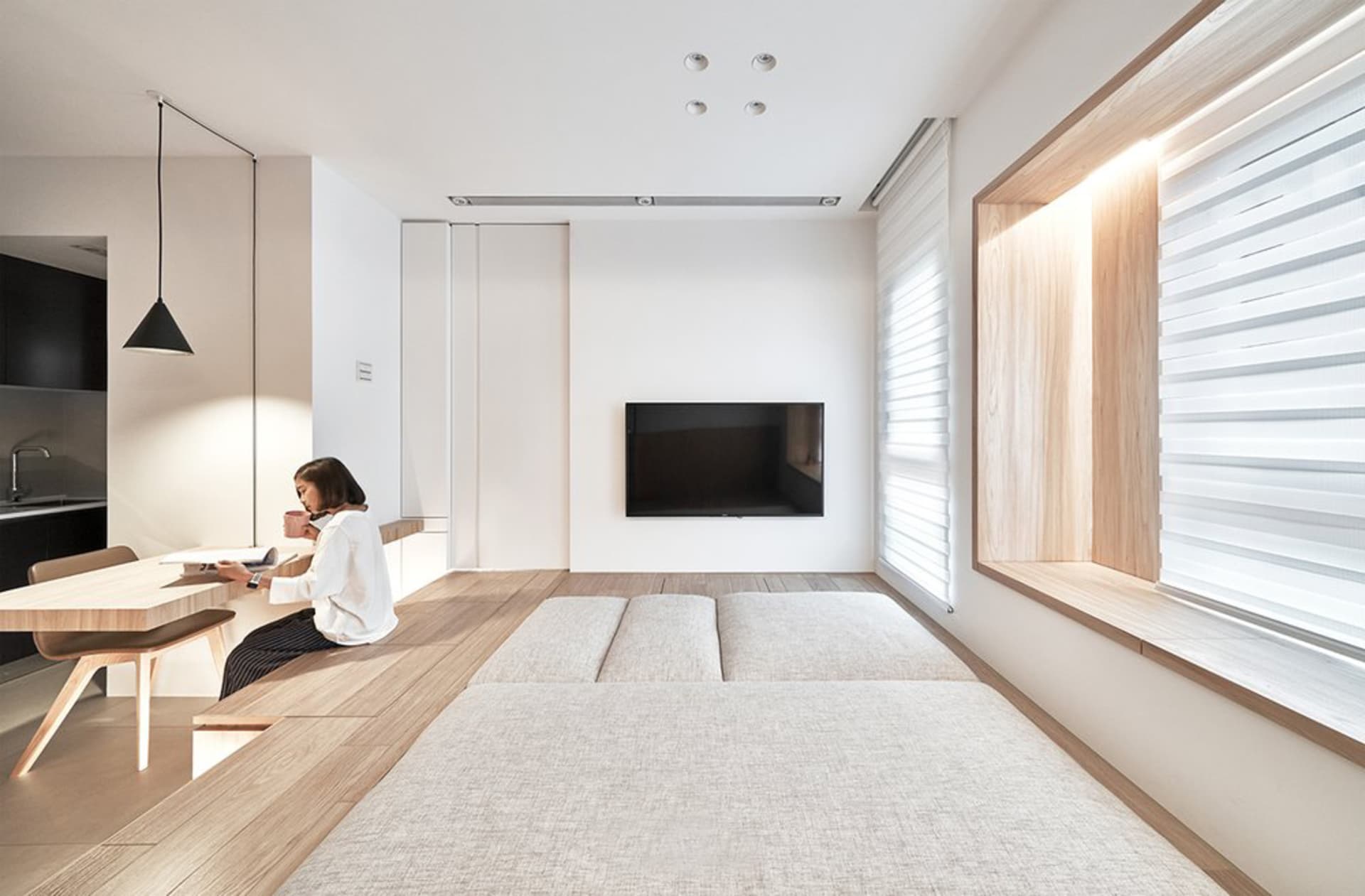 A modern residential interior featuring minimalist design, wood flooring, and laminate surfaces.