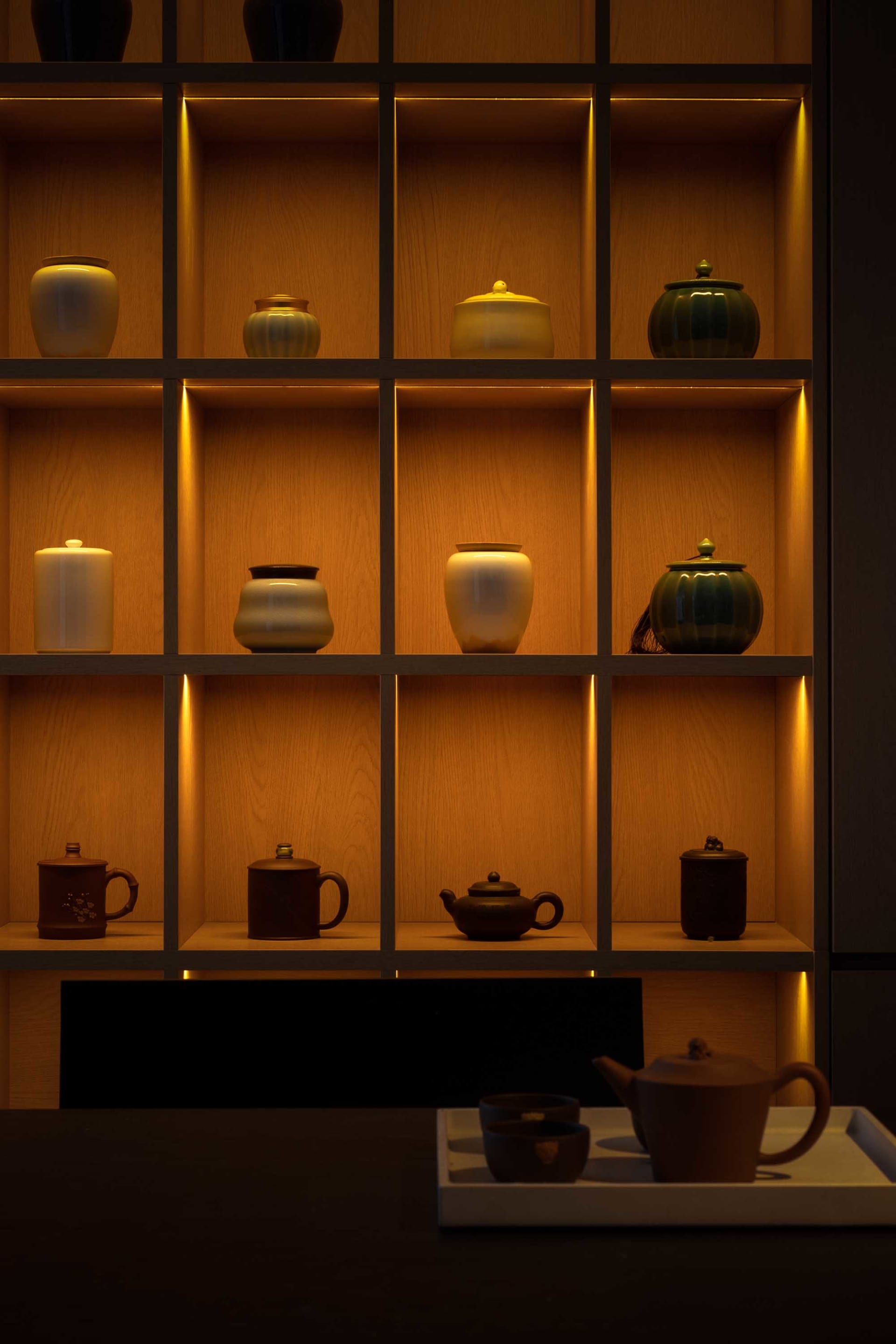Traditional tea ceremony setting featuring clay jars and shelves.