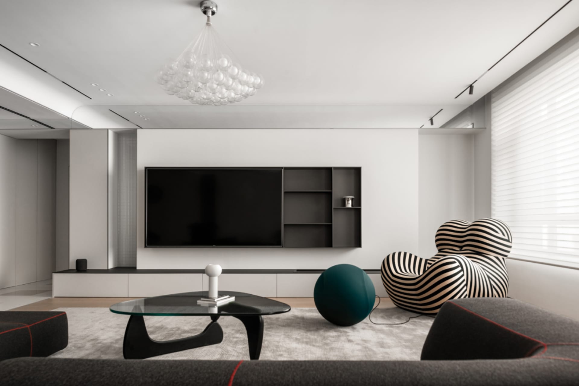 Modern living room with black, white, and green accents, featuring an abstract black frame table, black and white striped arm