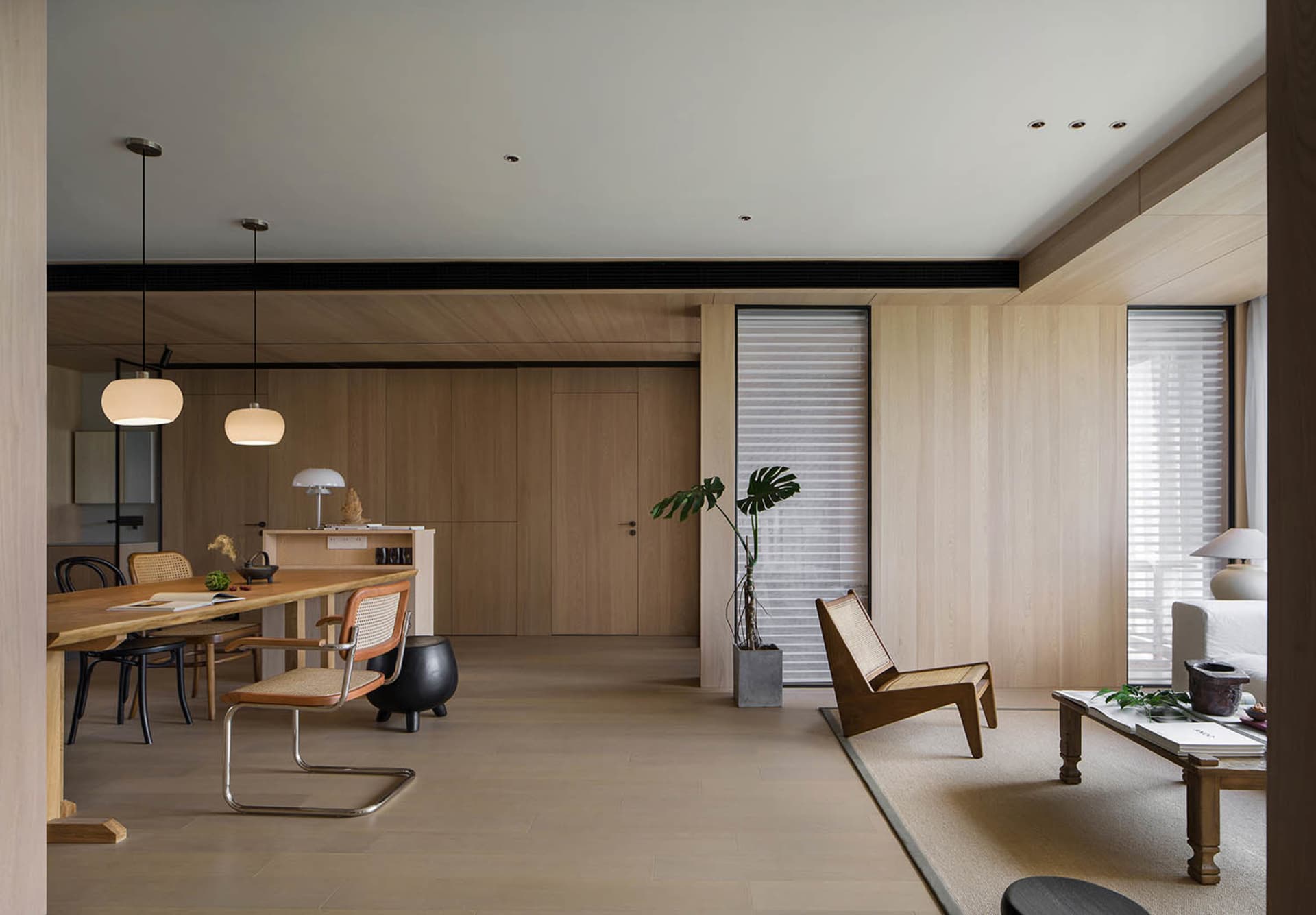 A minimalist living room with wooden furniture and a potted plant.