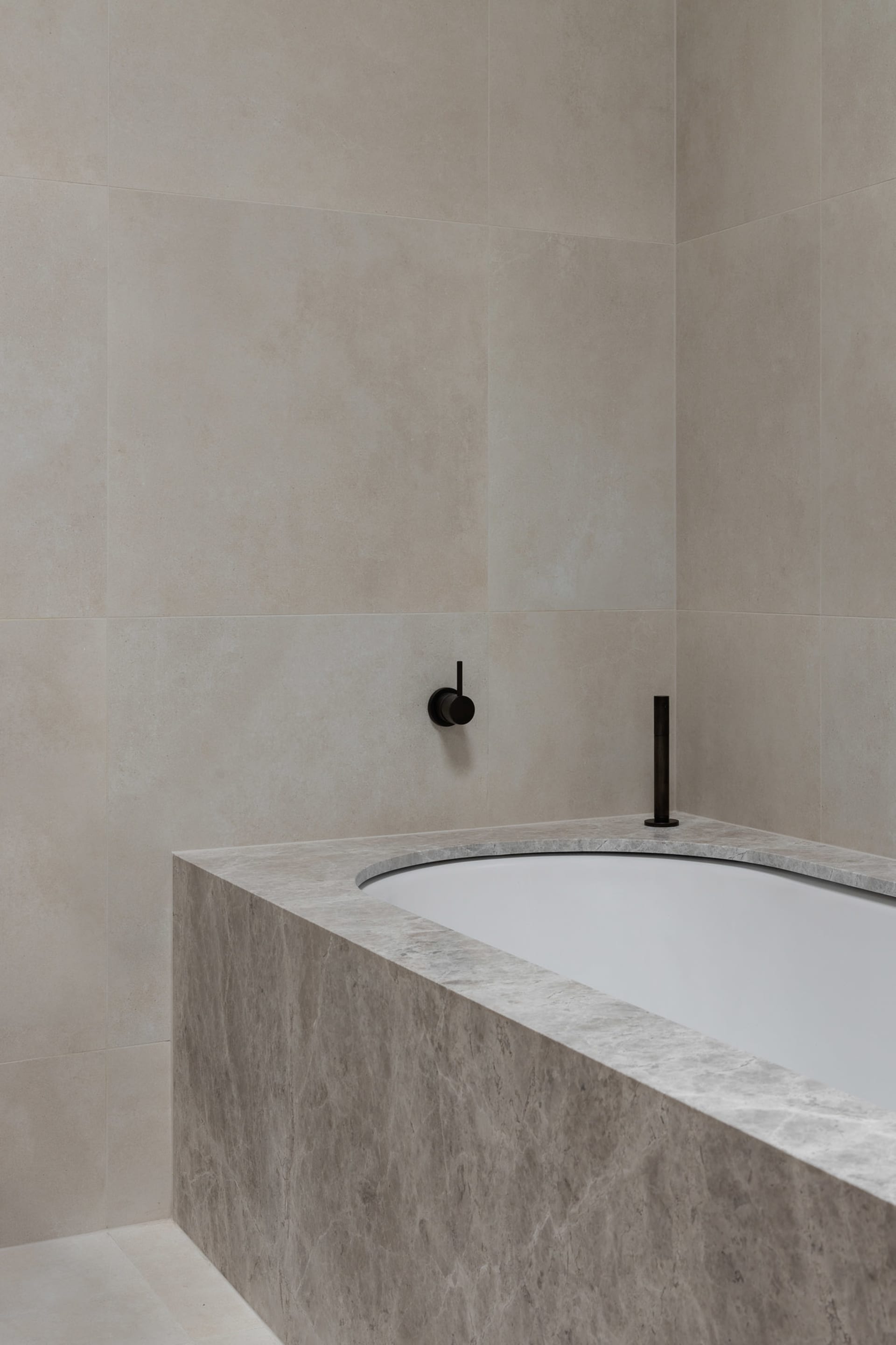 Modern minimalist bathroom featuring marble elements and a freestanding bathtub