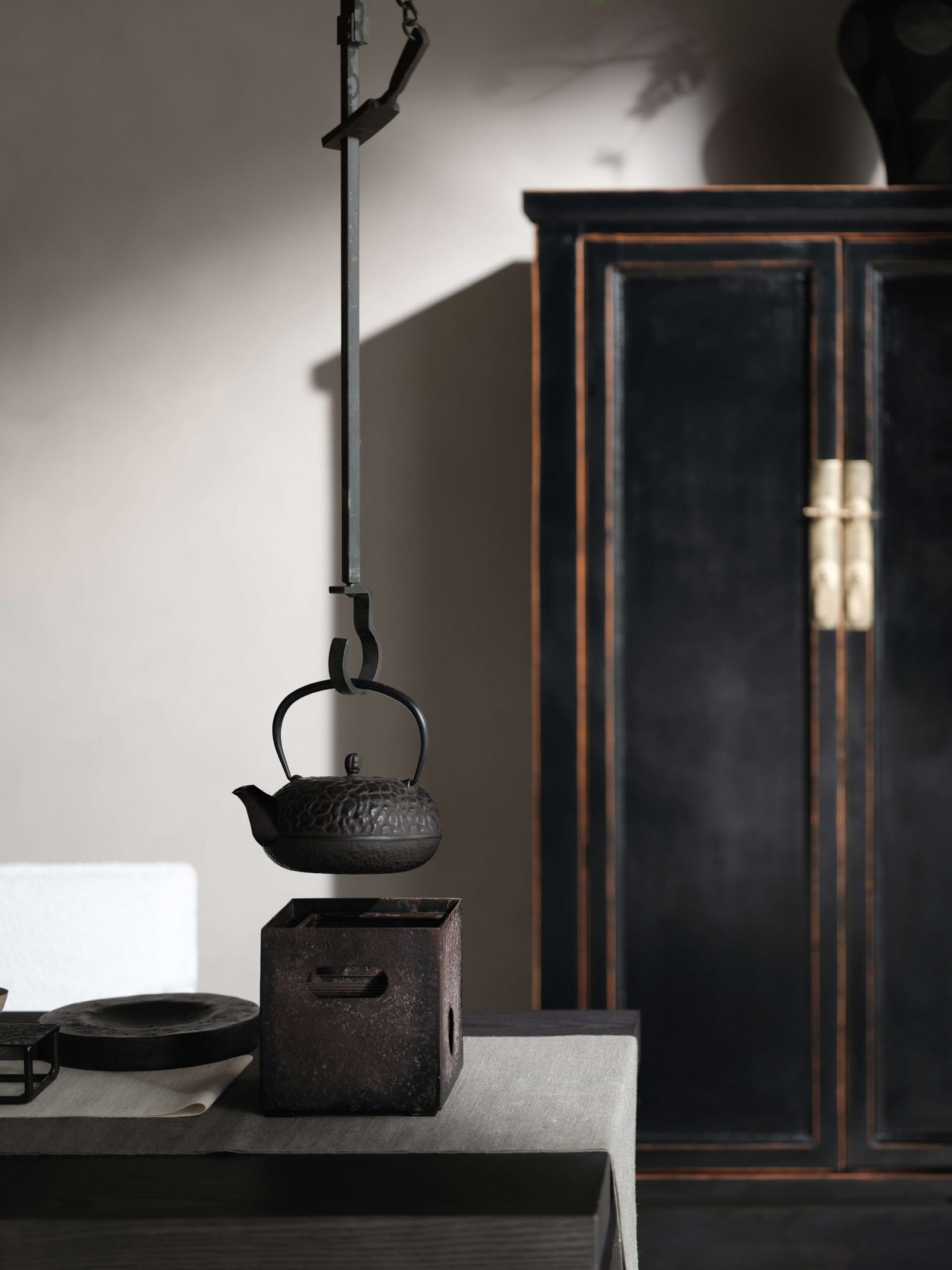 Industrial style interior design featuring a metal teapot hanging from a black metal rod.