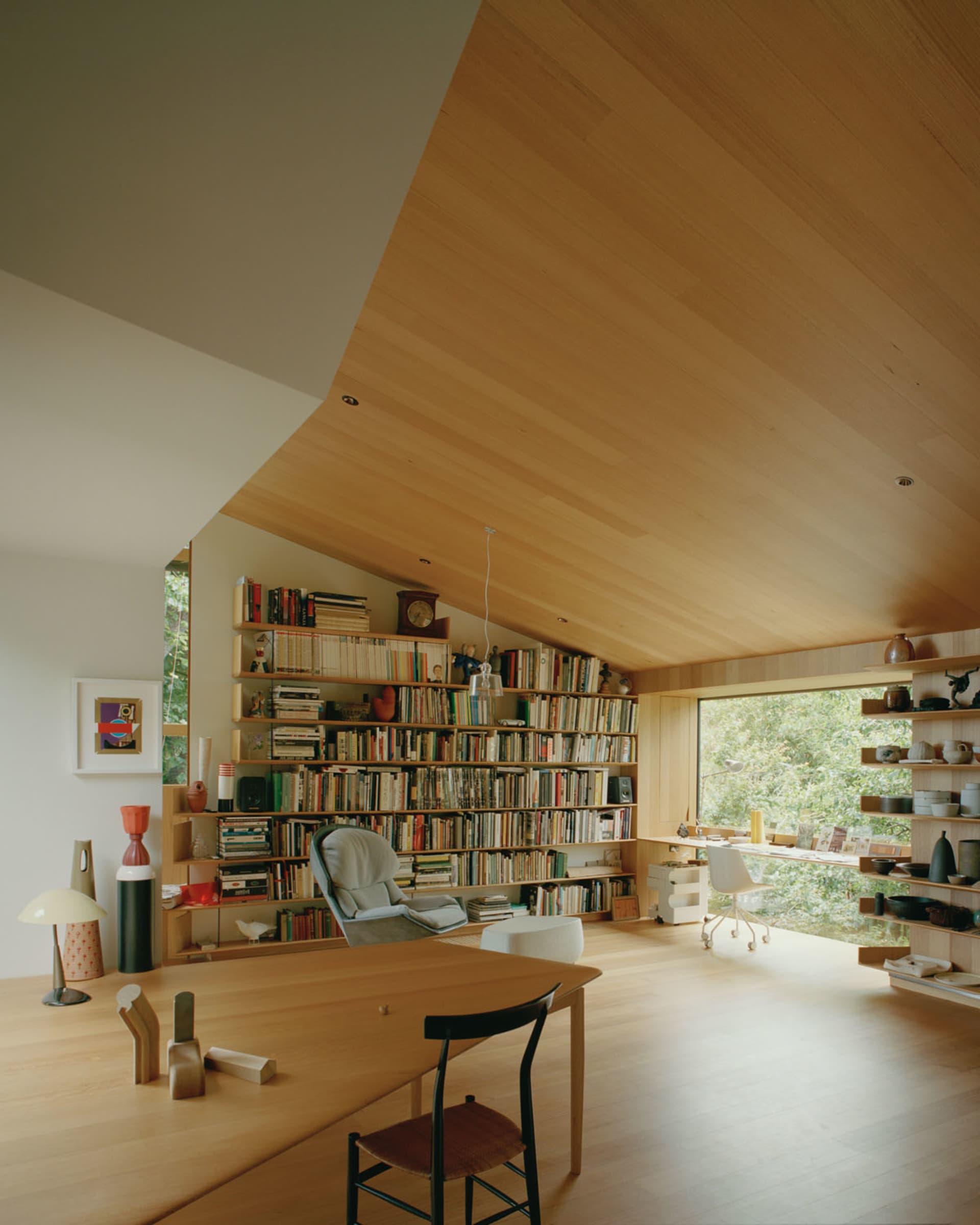 A modern library with wooden shelves filled with books.