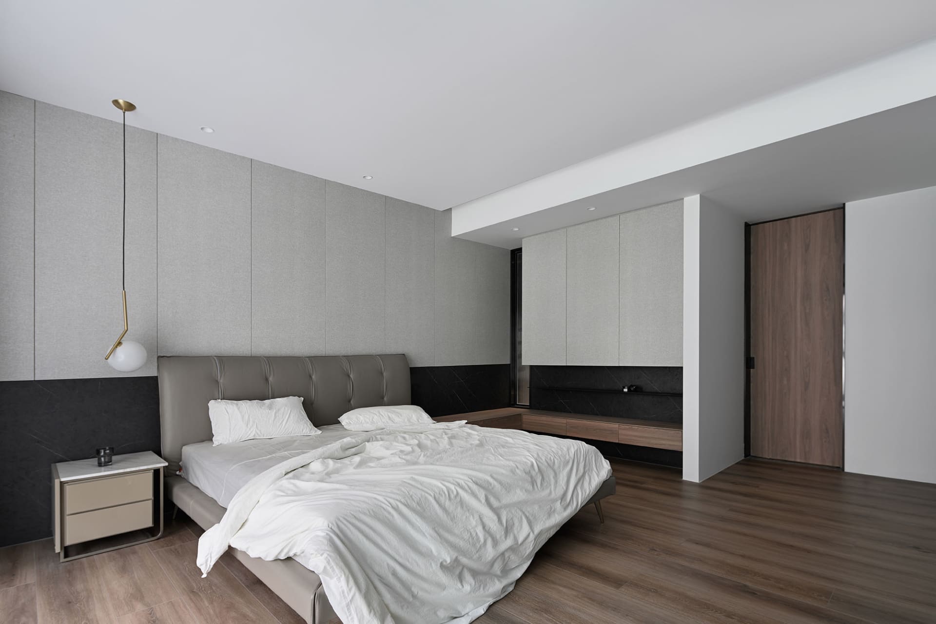 簡約臥室內有帶有質感床頭板的床鋪、白色的床具,以及木質地板。