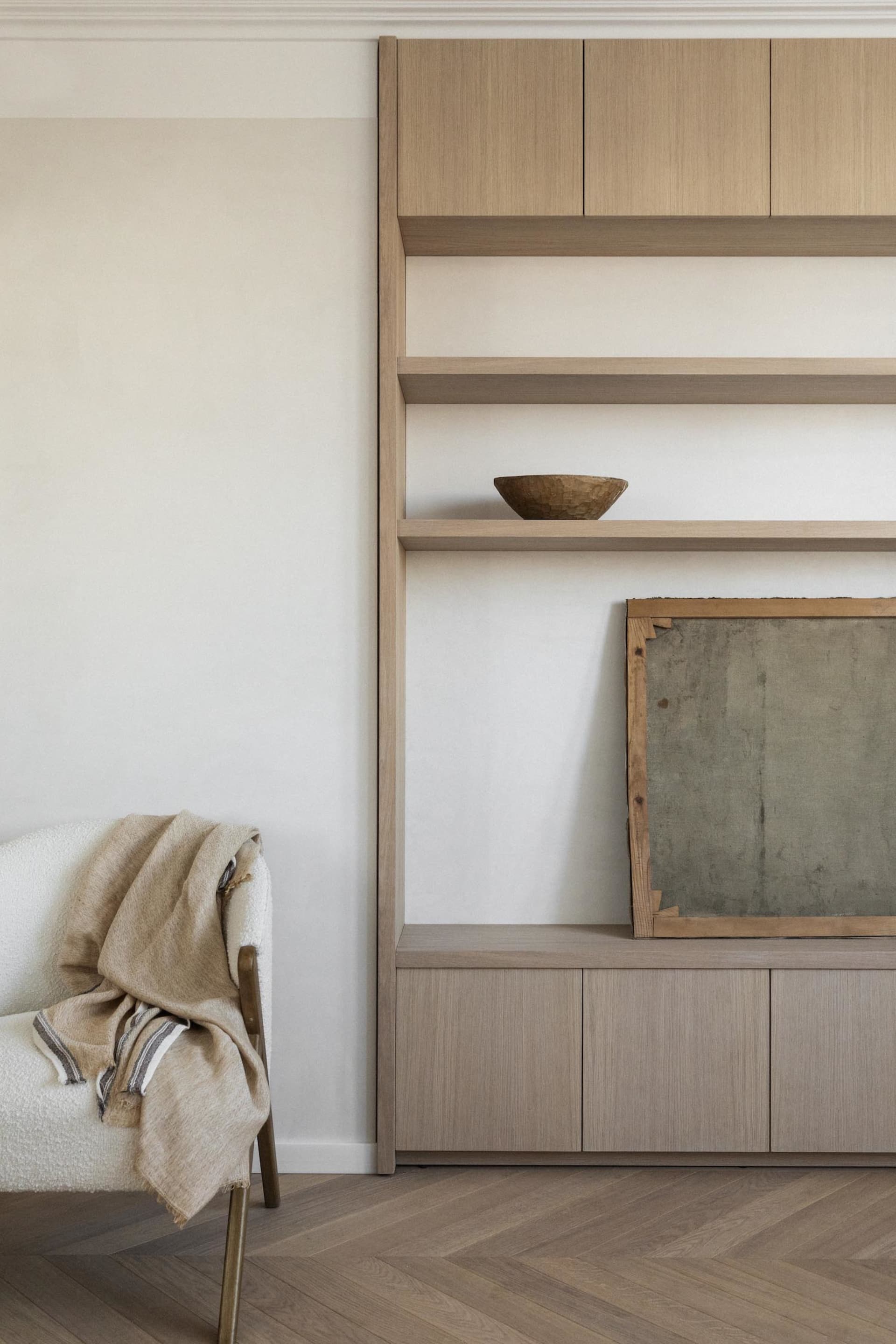 A modern minimalist living room featuring wooden shelving.