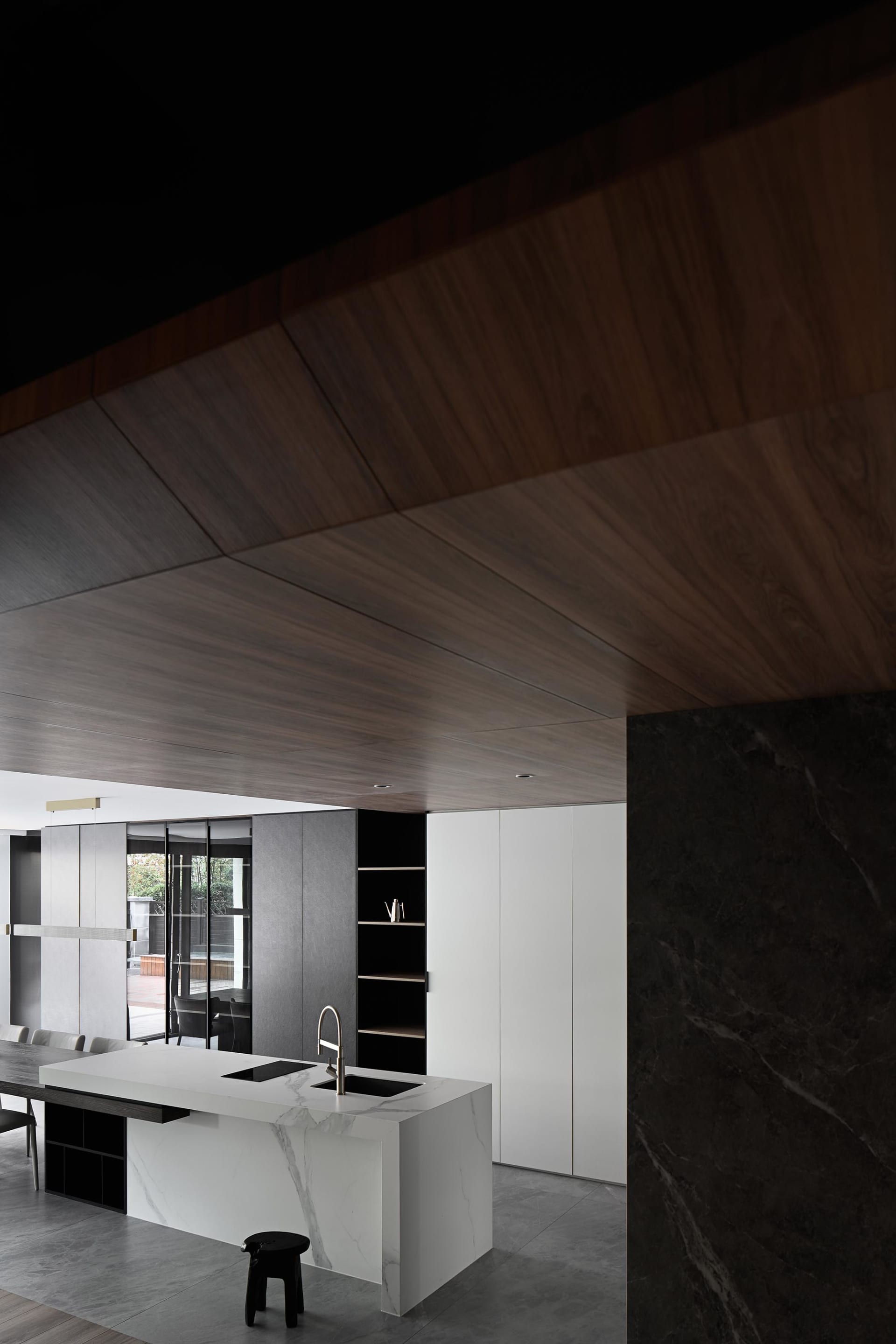 Modern kitchen with minimalist design, featuring a marble countertop and wooden cabinets.