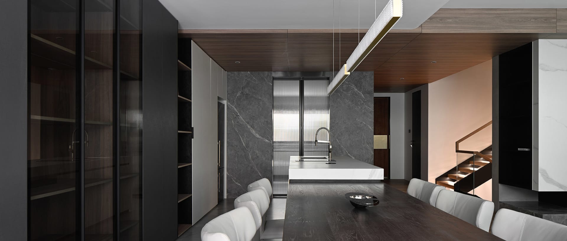 A modern kitchen and dining area featuring marble surfaces.