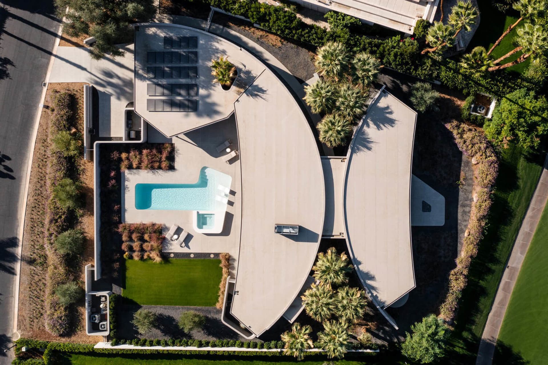 A modern minimalist residential interior with a curved concrete structure and glass elements.