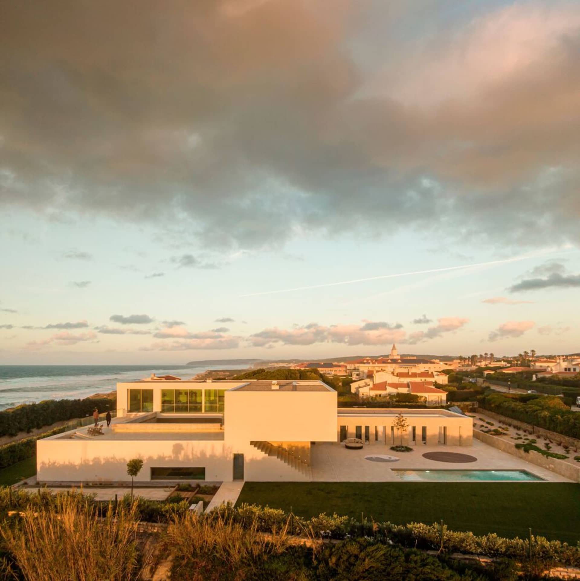 Modern residential home with concrete, glass, and metal exterior.