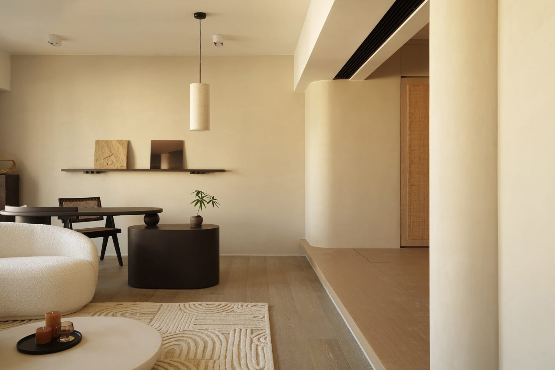 A minimalist living room with concrete furniture and wooden flooring.