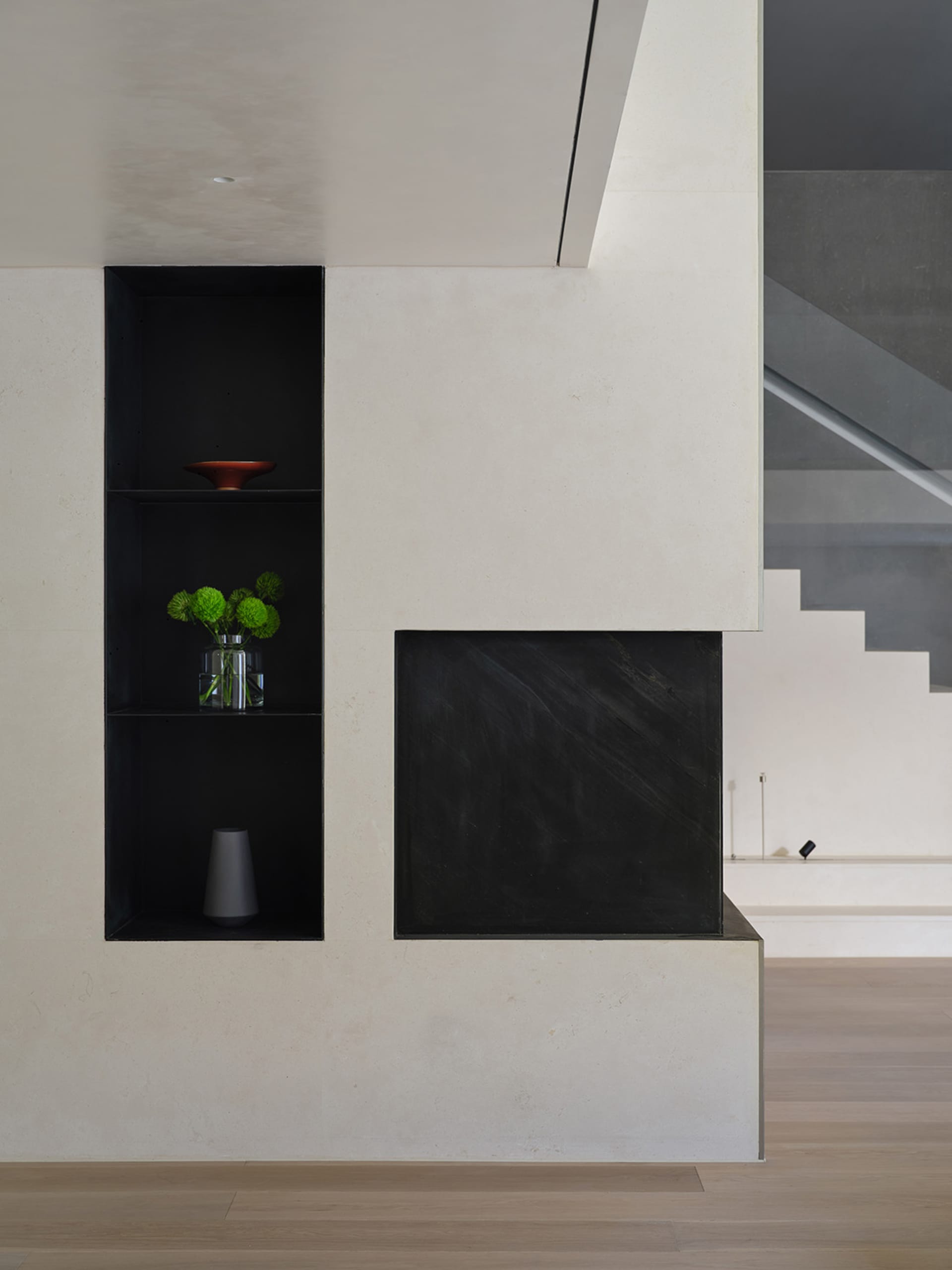 Modern interior design featuring a concrete shelving unit with minimalist black shelves and decorative elements.