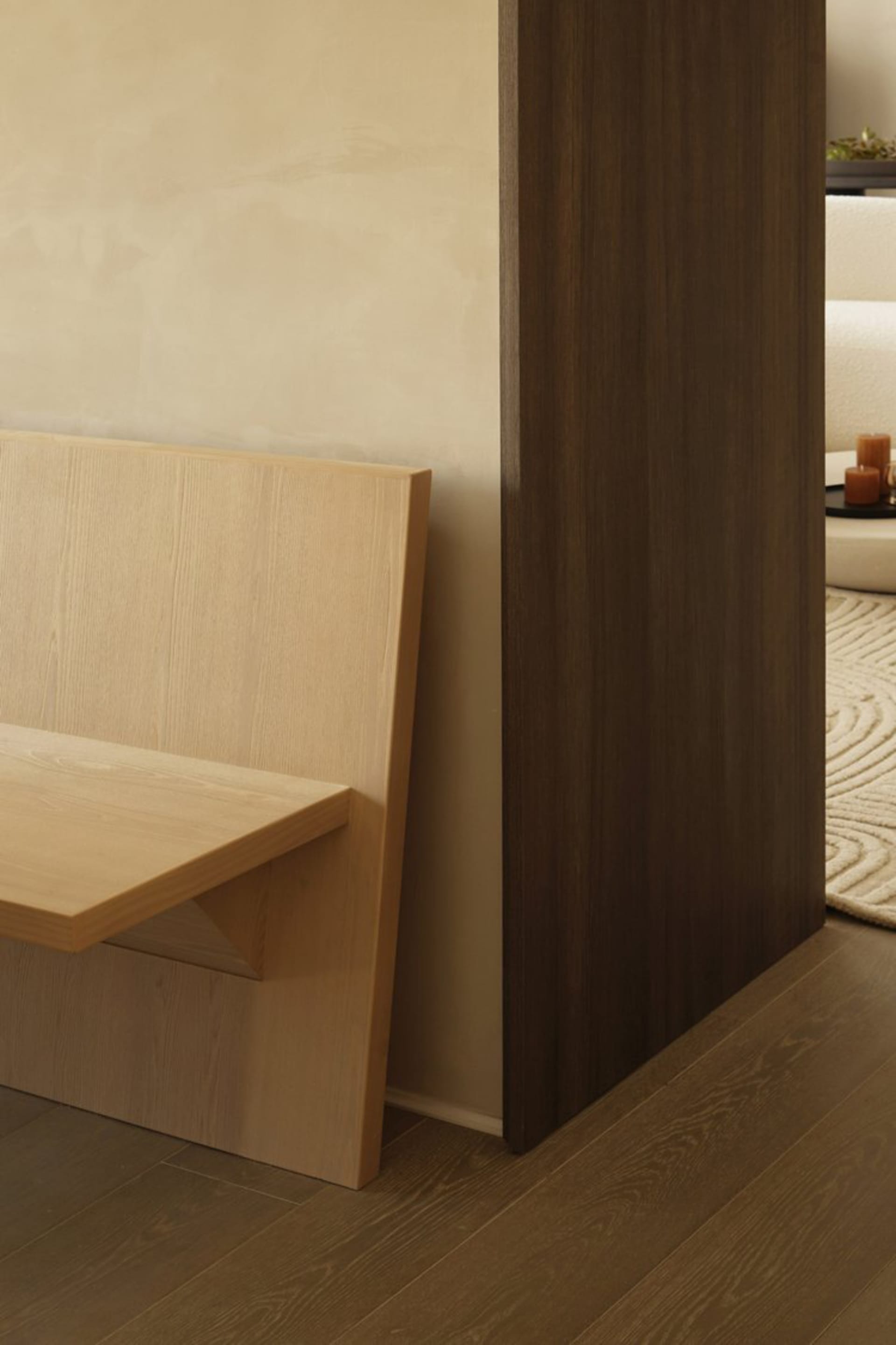 A minimalist wooden bench in a modern interior space.