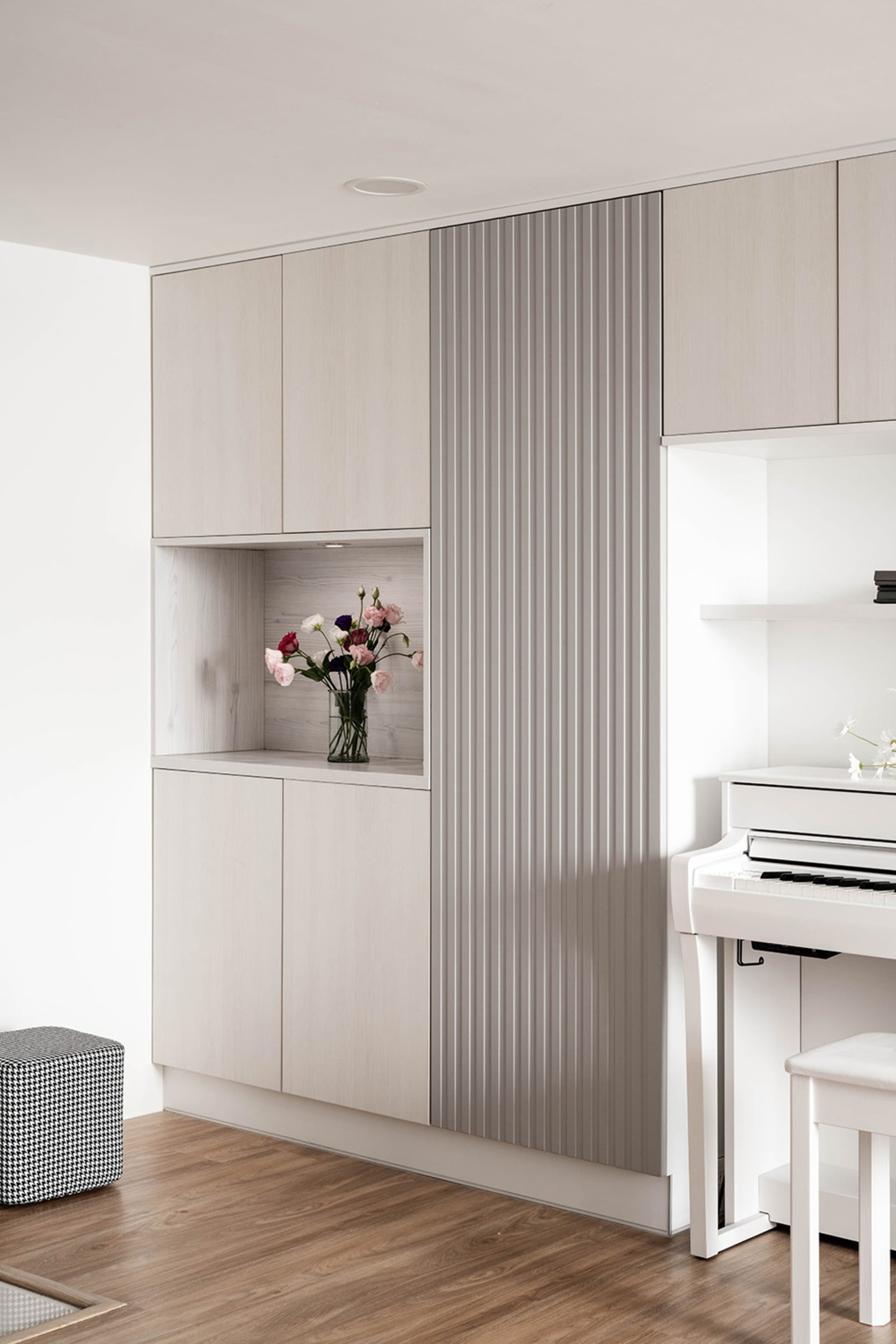 Modern minimalist living room with wooden cabinets and a white piano.