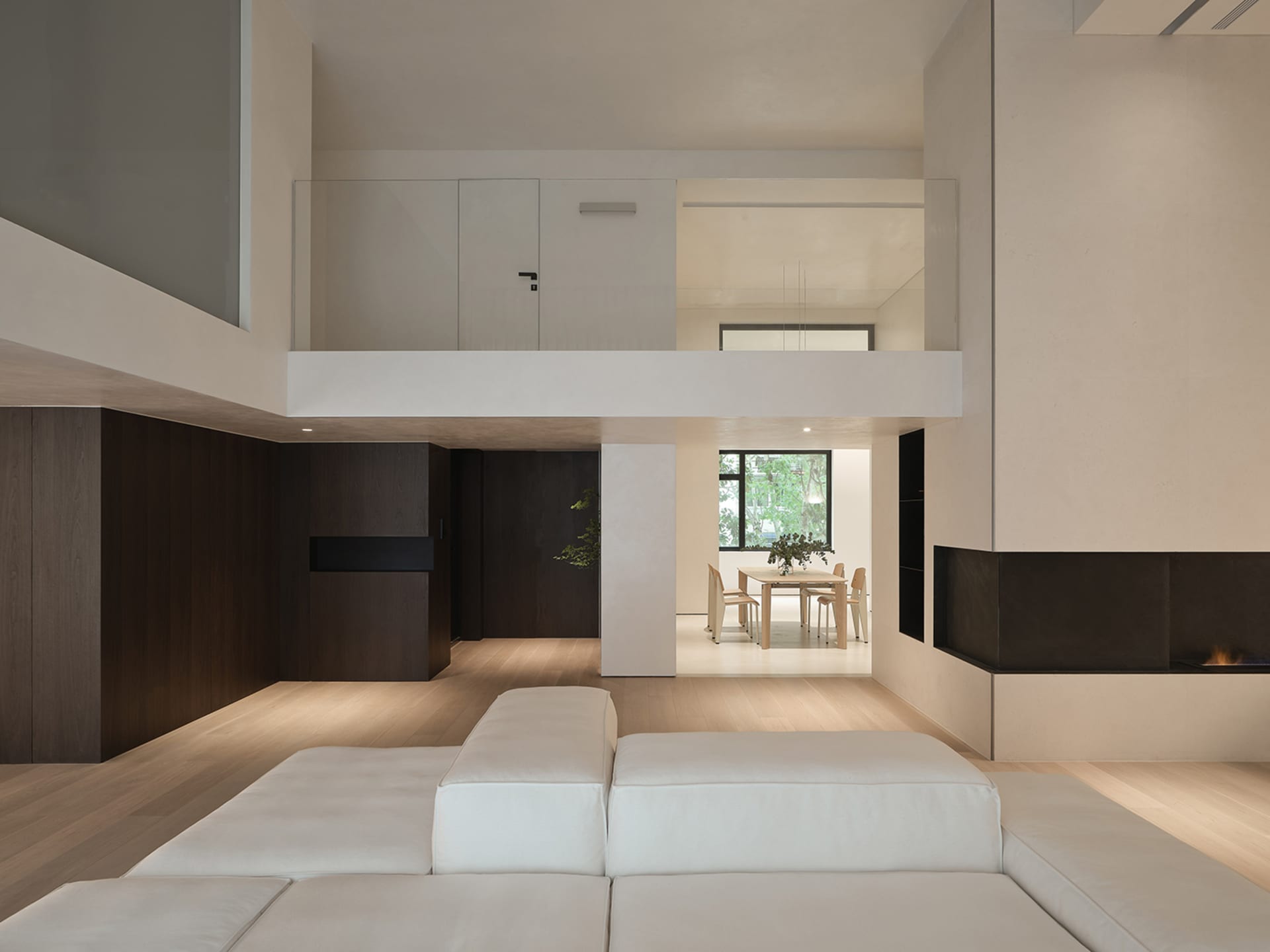Modern minimalist living room with wooden furniture, concrete accents, and textiles on the floor.