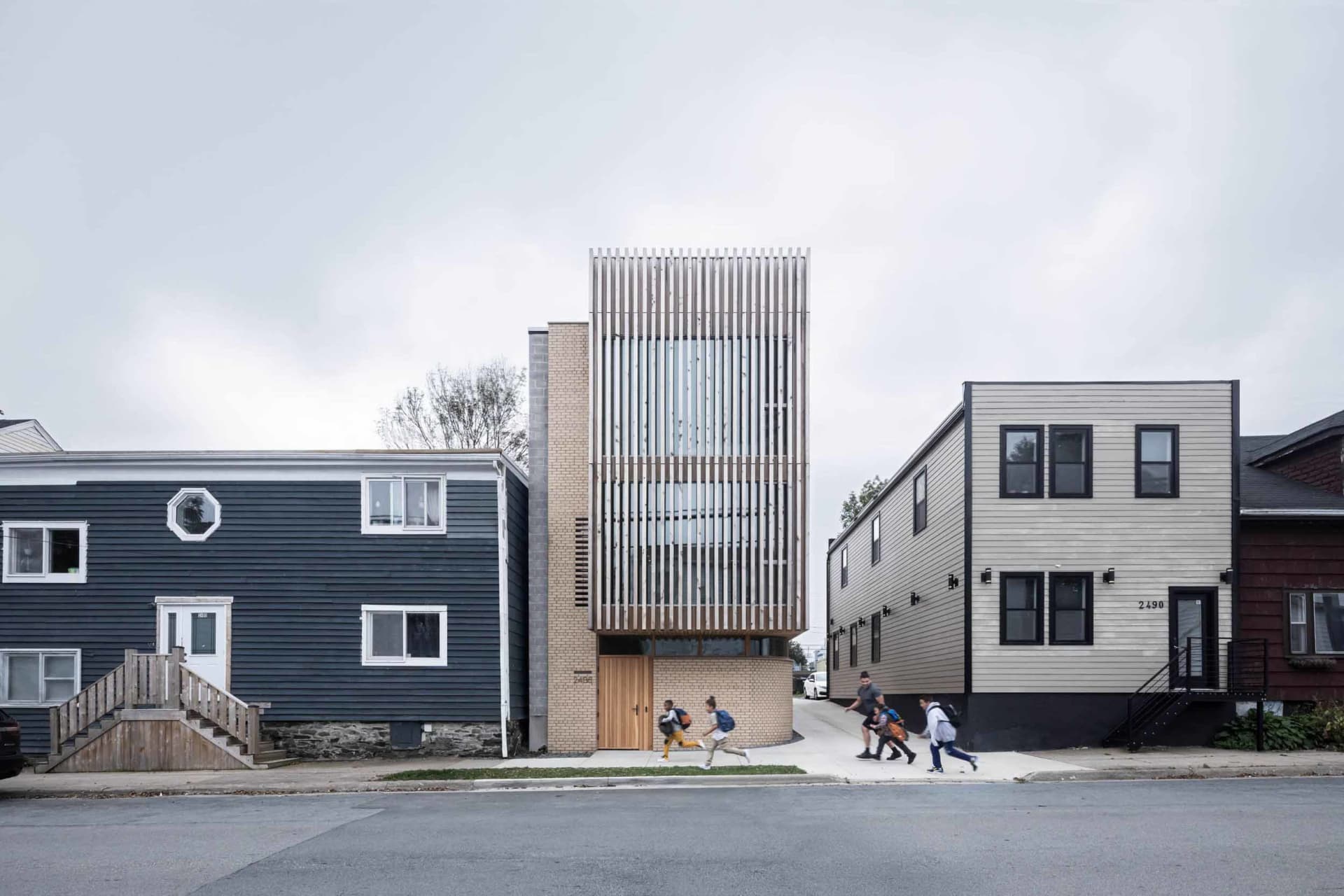 A modern residential building with brick, wood, and metal elements.