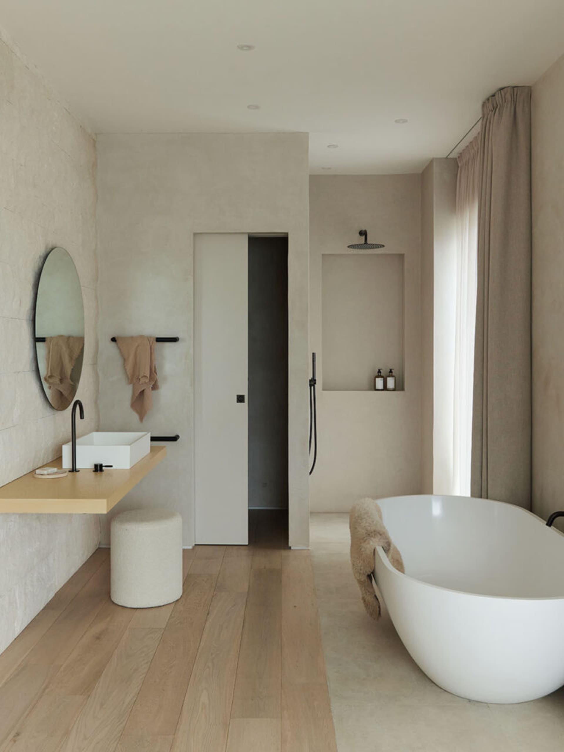 Modern bathroom with concrete walls, a freestanding bathtub, and minimalist design.