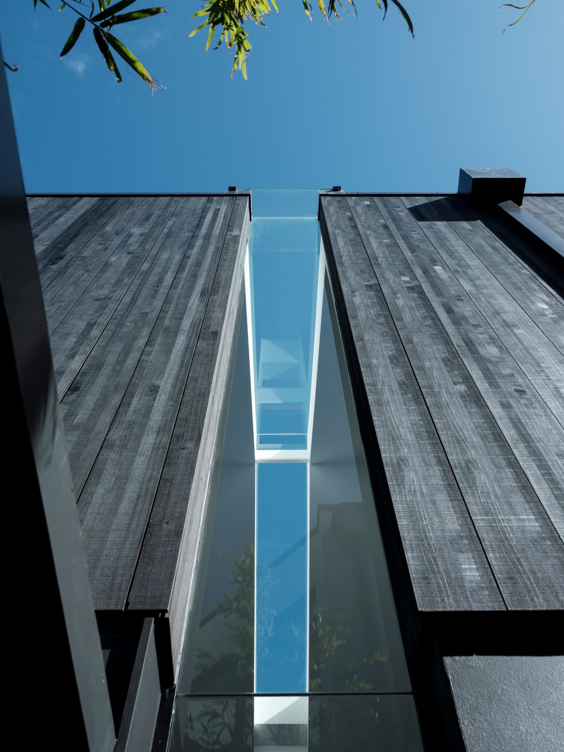 A modern building with a glass walkway connecting two structures.
