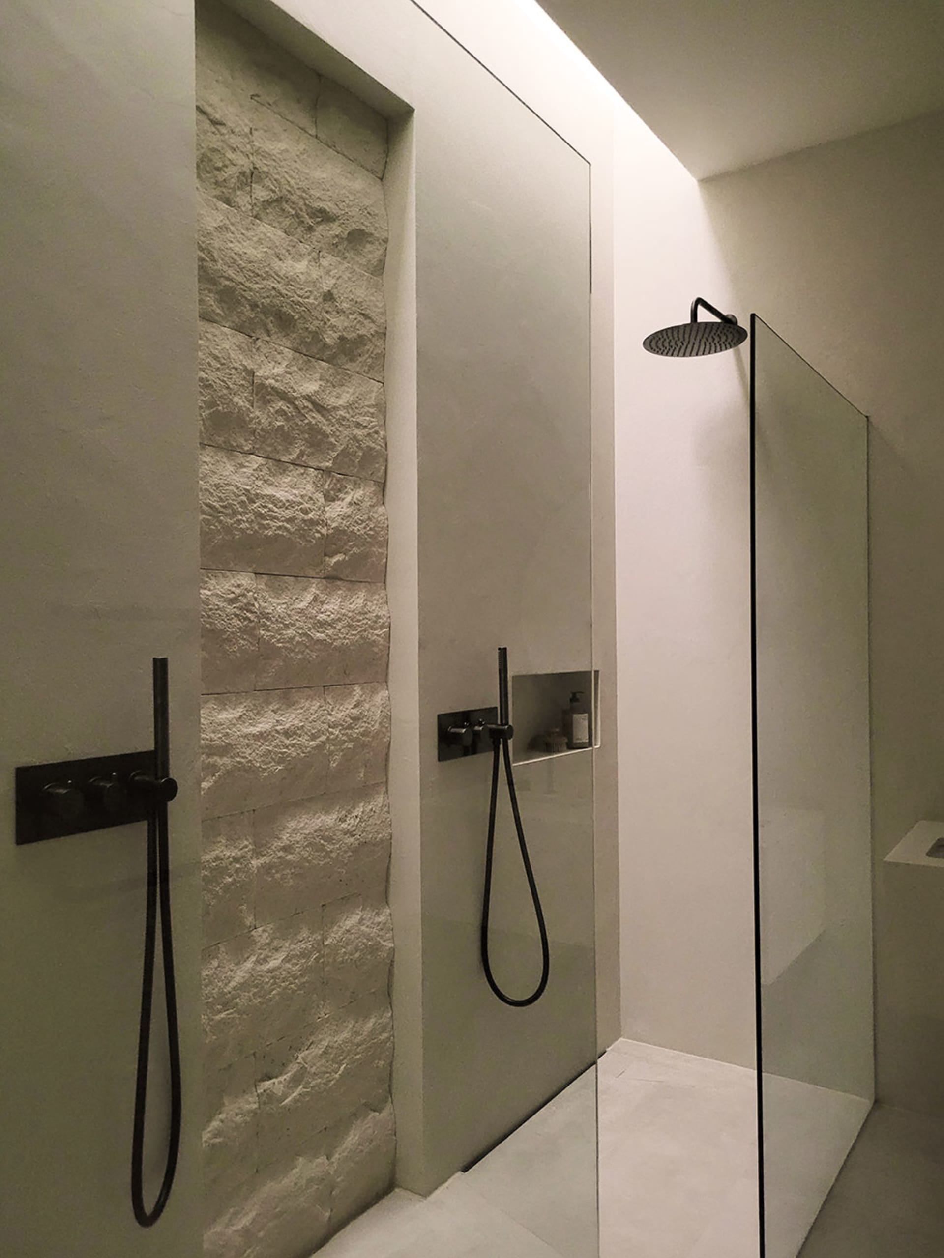 Modern minimalist bathroom featuring concrete walls and a walk-in shower.