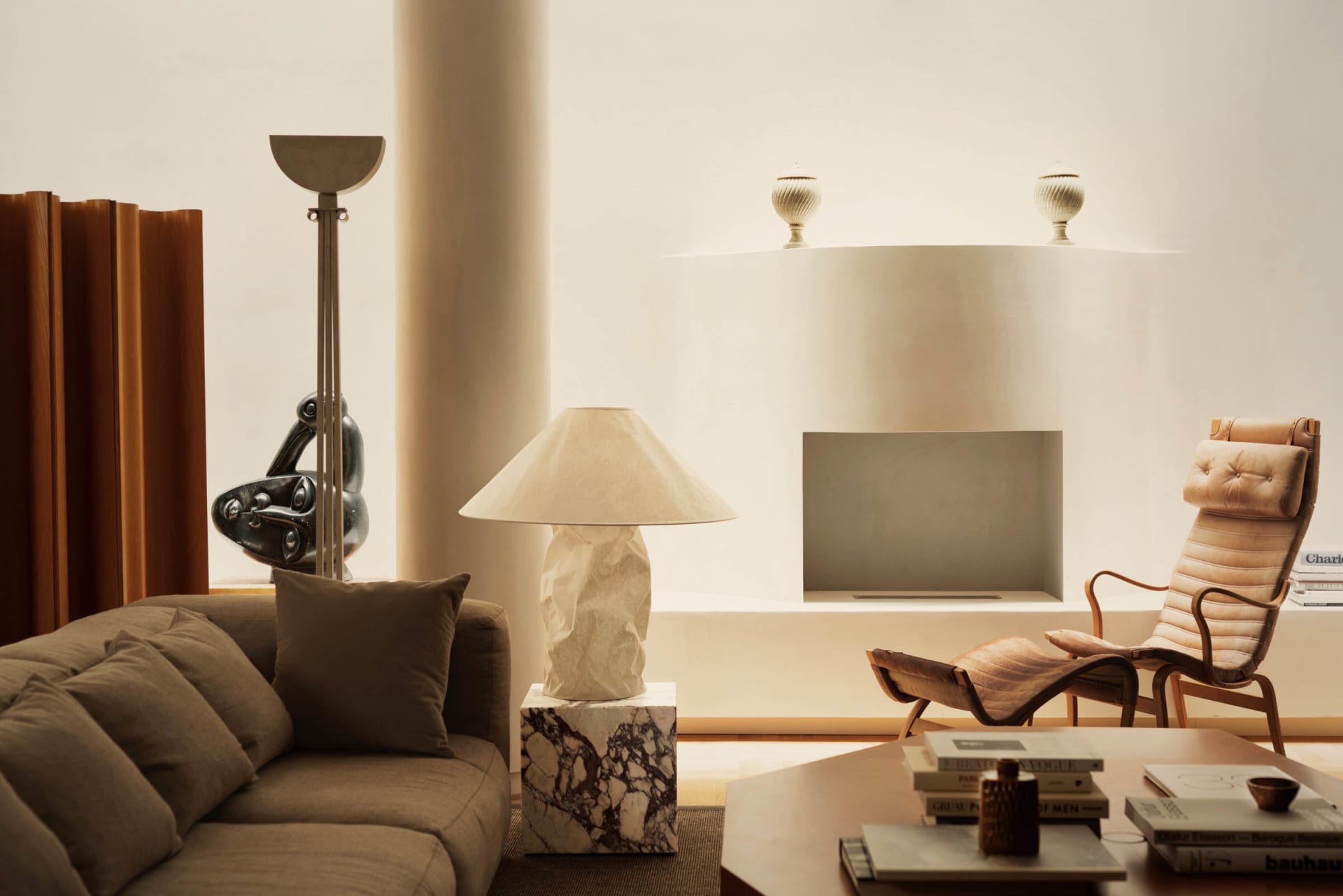 A minimalist living room featuring marble and leather elements.