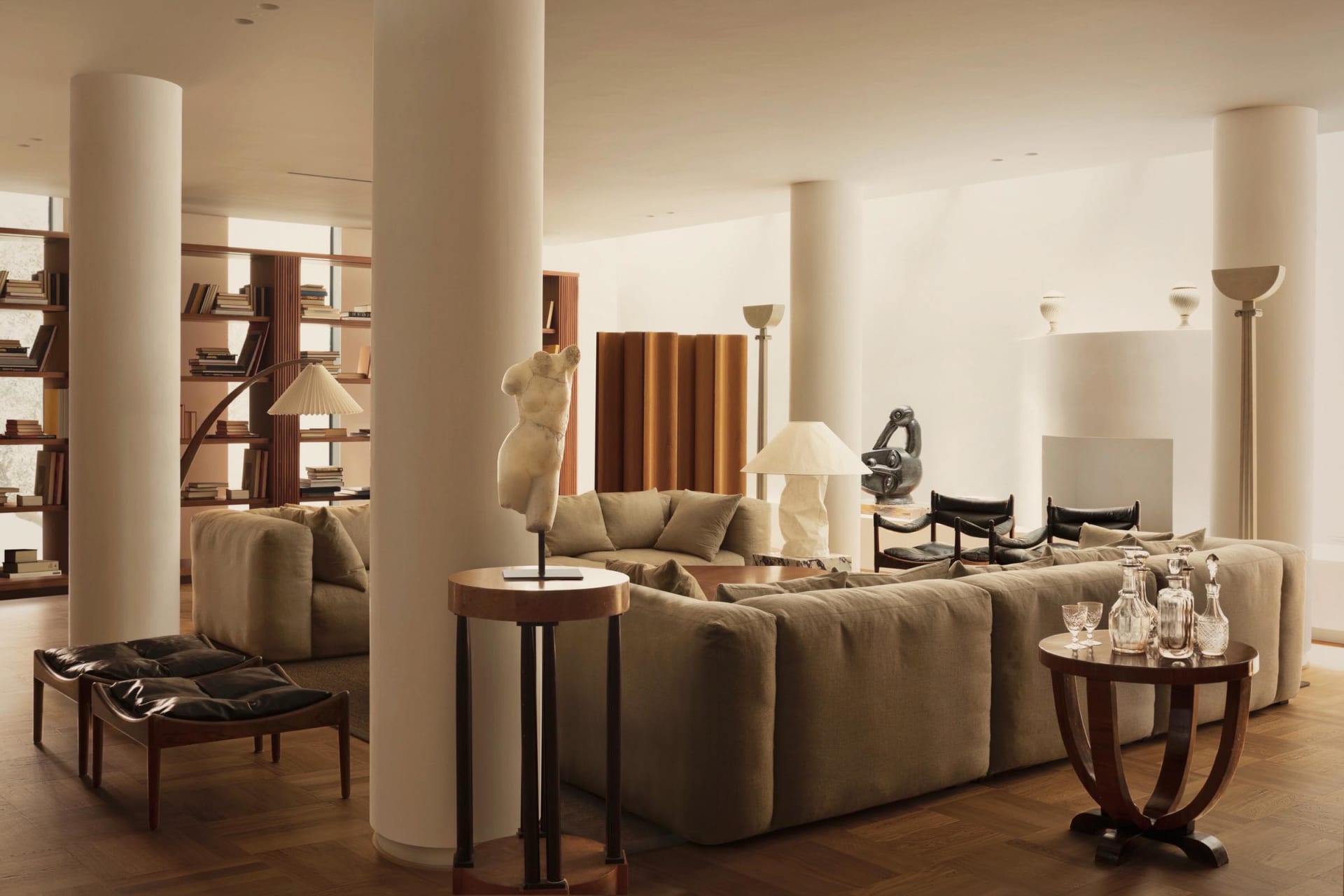 Modern living room with contemporary furniture, plush sofas, and decorative sculptures.