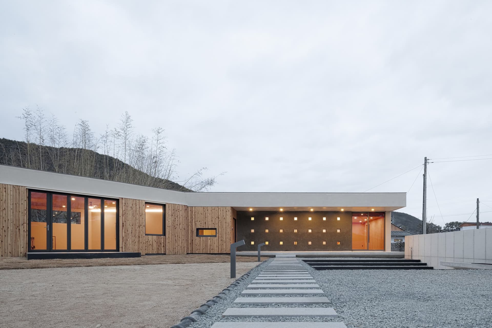 Modern residential house with wooden siding and large windows.