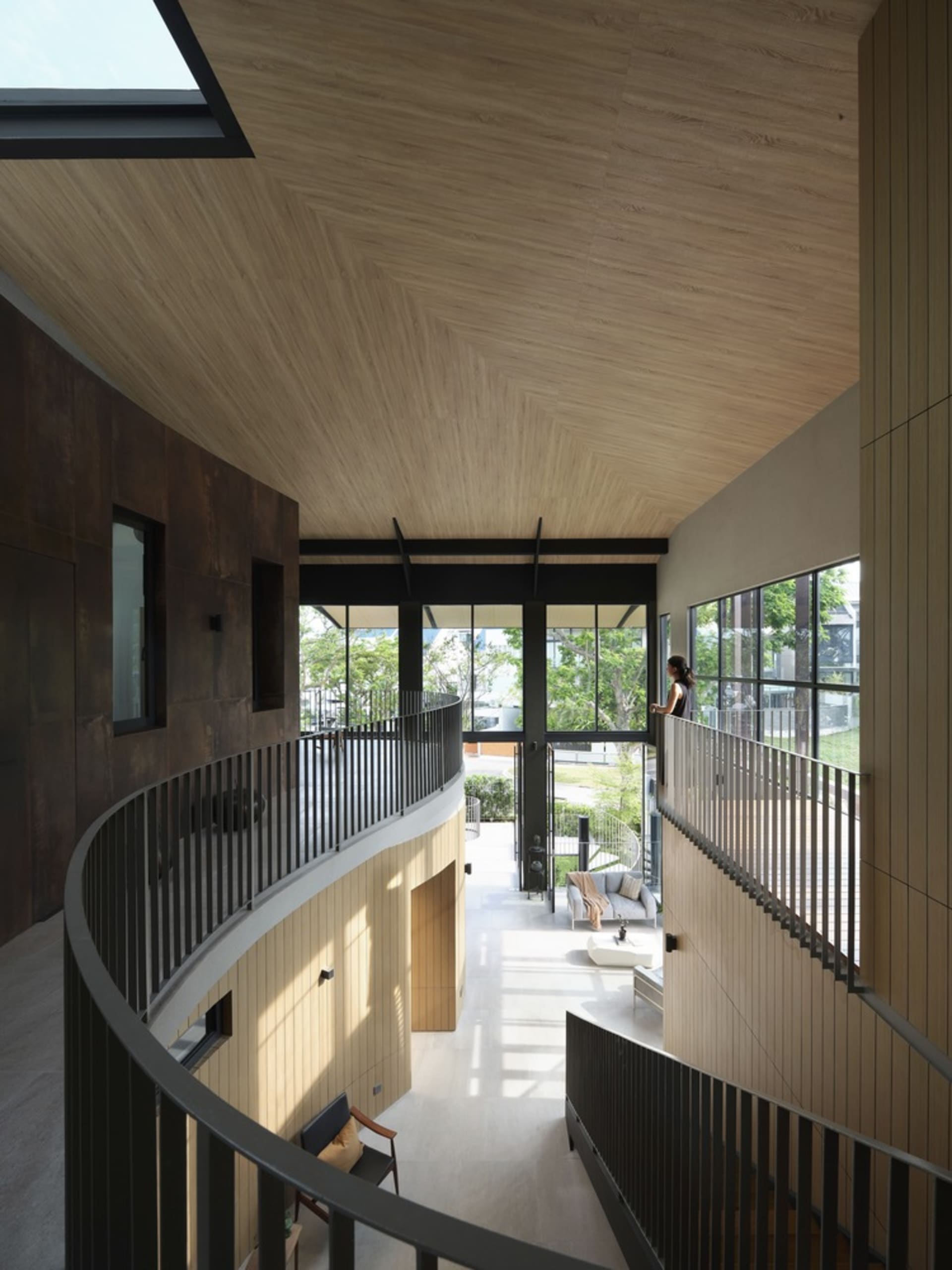 A modern residential interior showing a living space with wooden elements and large windows.