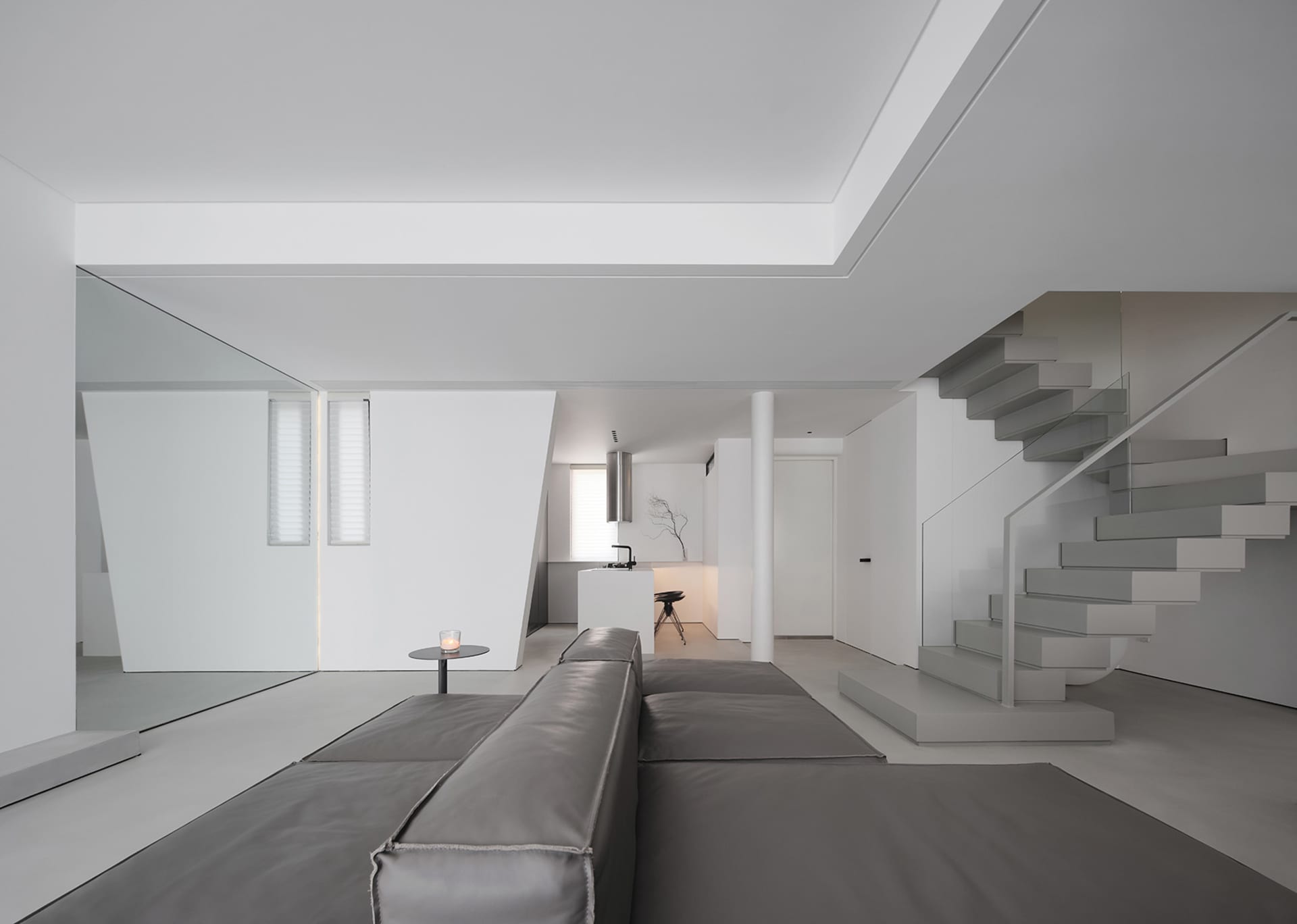 Modern minimalist living room featuring concrete, glass, and metal elements
