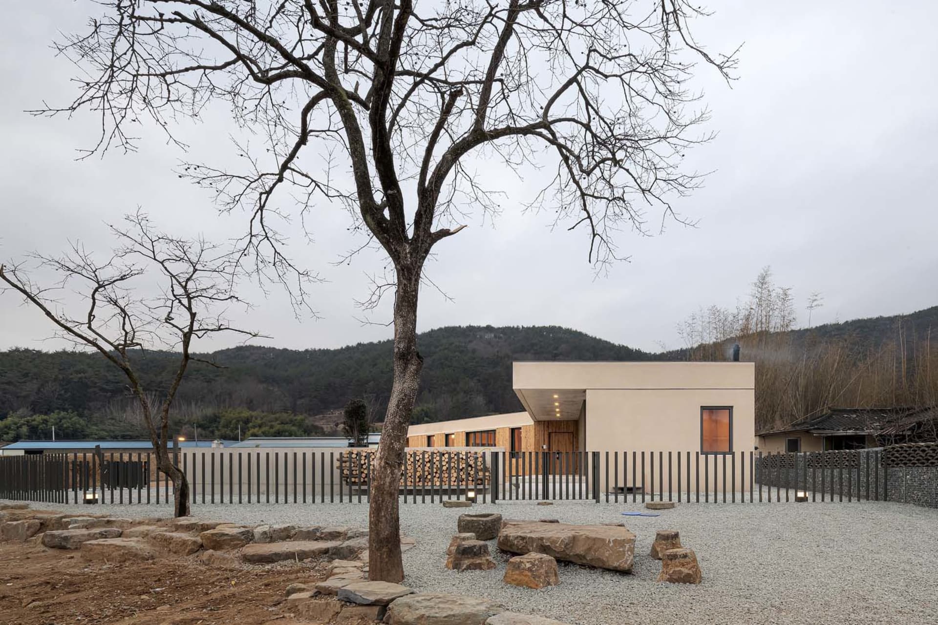 A modern residential home with a minimalist exterior featuring wood, stone, and metal.