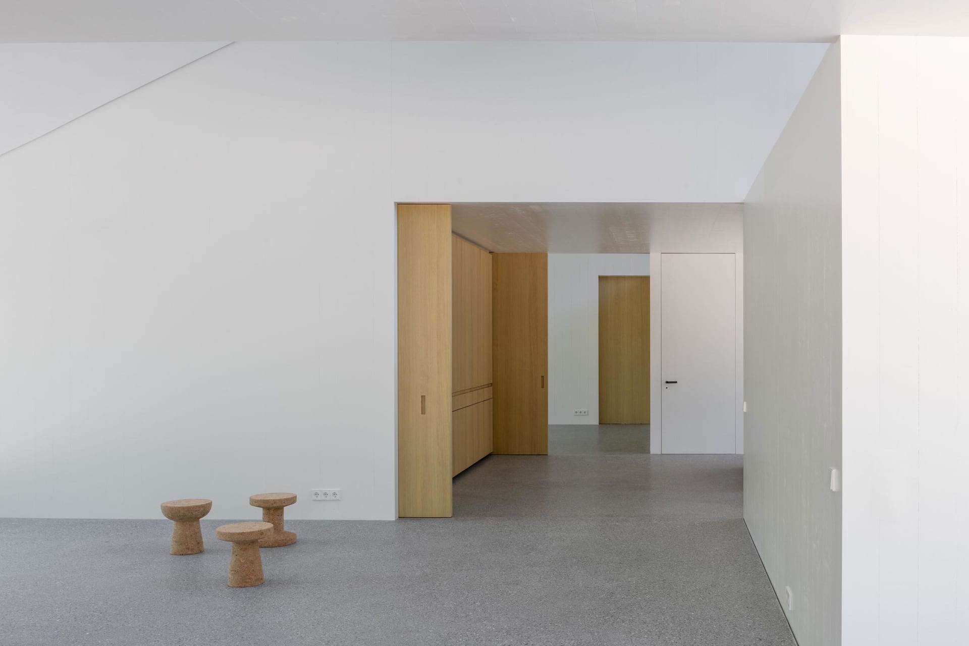 A modern office space with concrete flooring and wooden furniture.