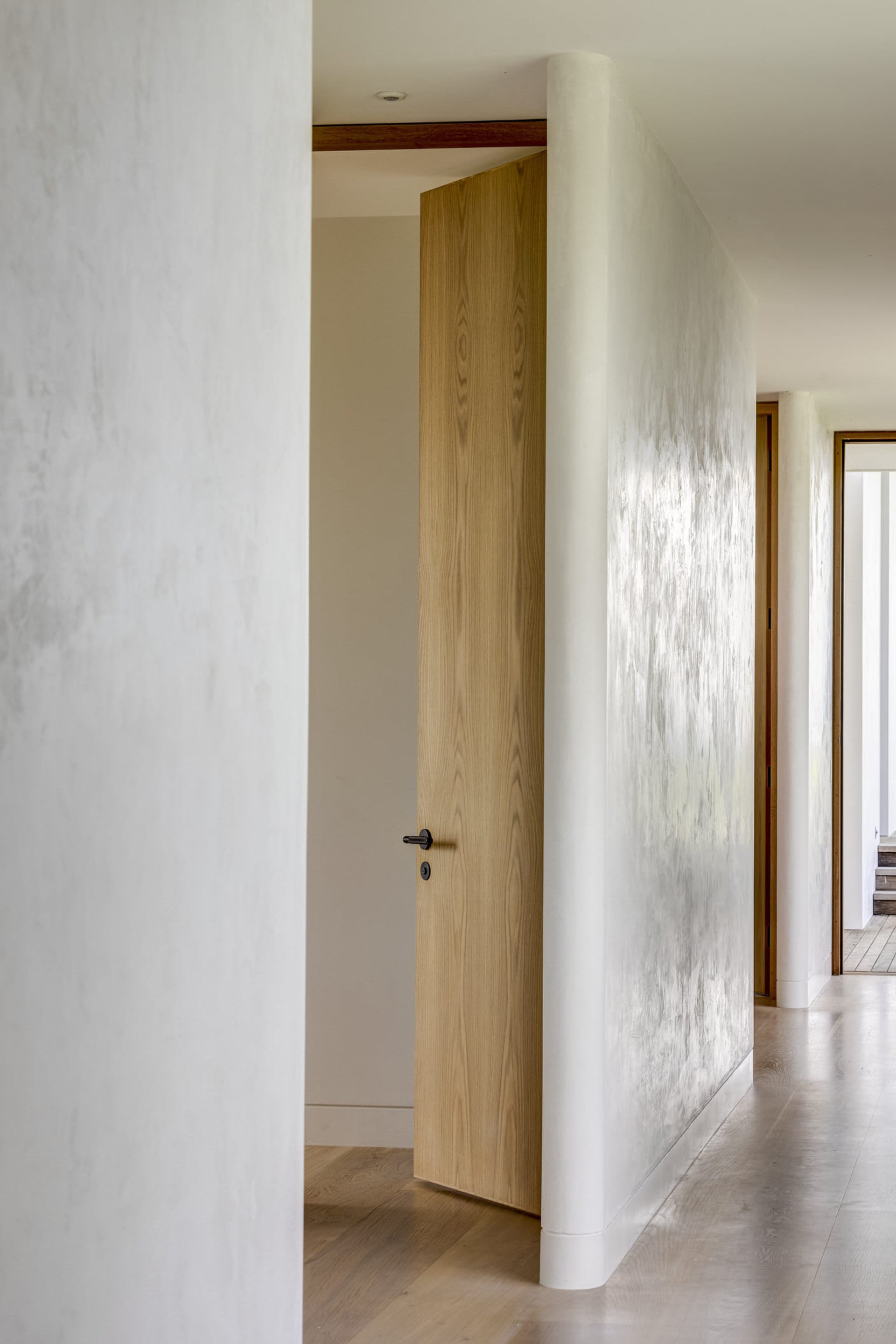 A minimalist interior featuring a wooden door.